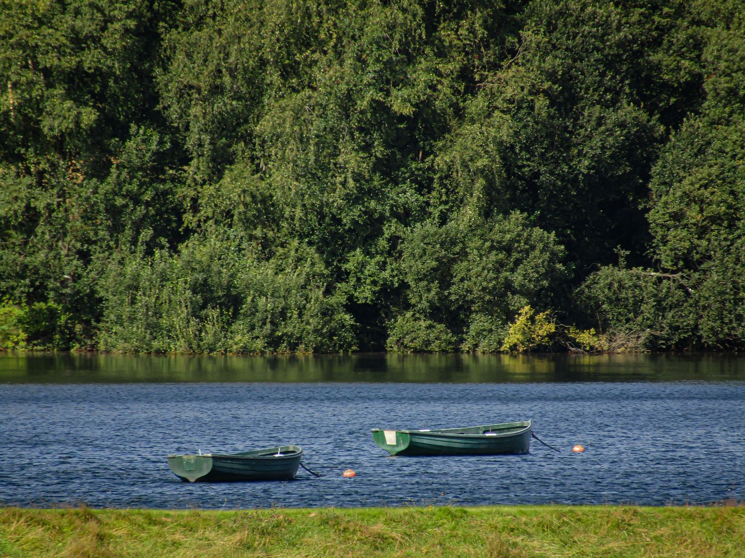 Fine art photo two green wooden rowing boats on calm blue lake, available as framed wall art prints and downloads.