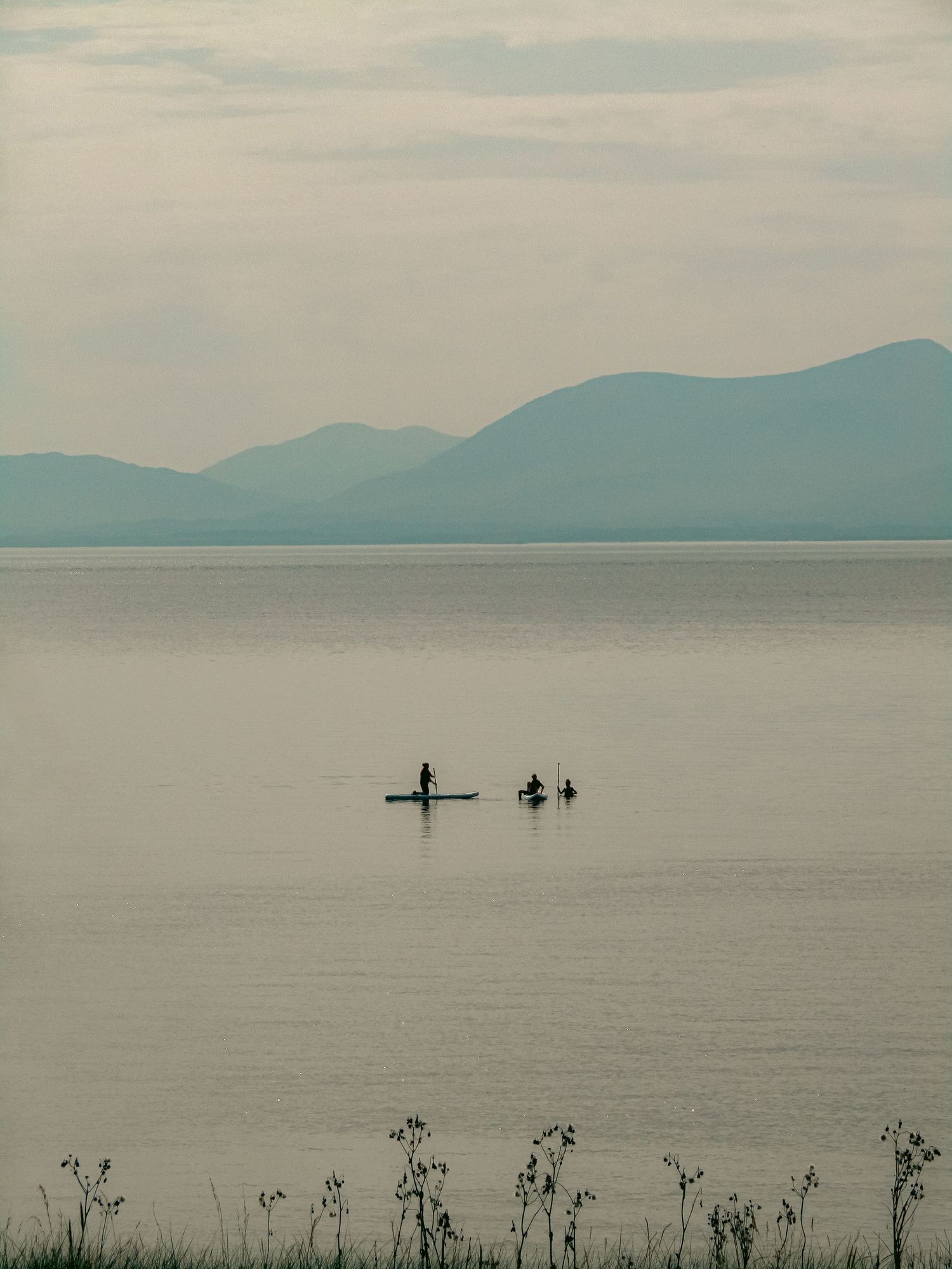 Fine art minimalist landscape paddleboarders on a tranquil misty lake with mountain outlines, framed wall art prints and downloads.