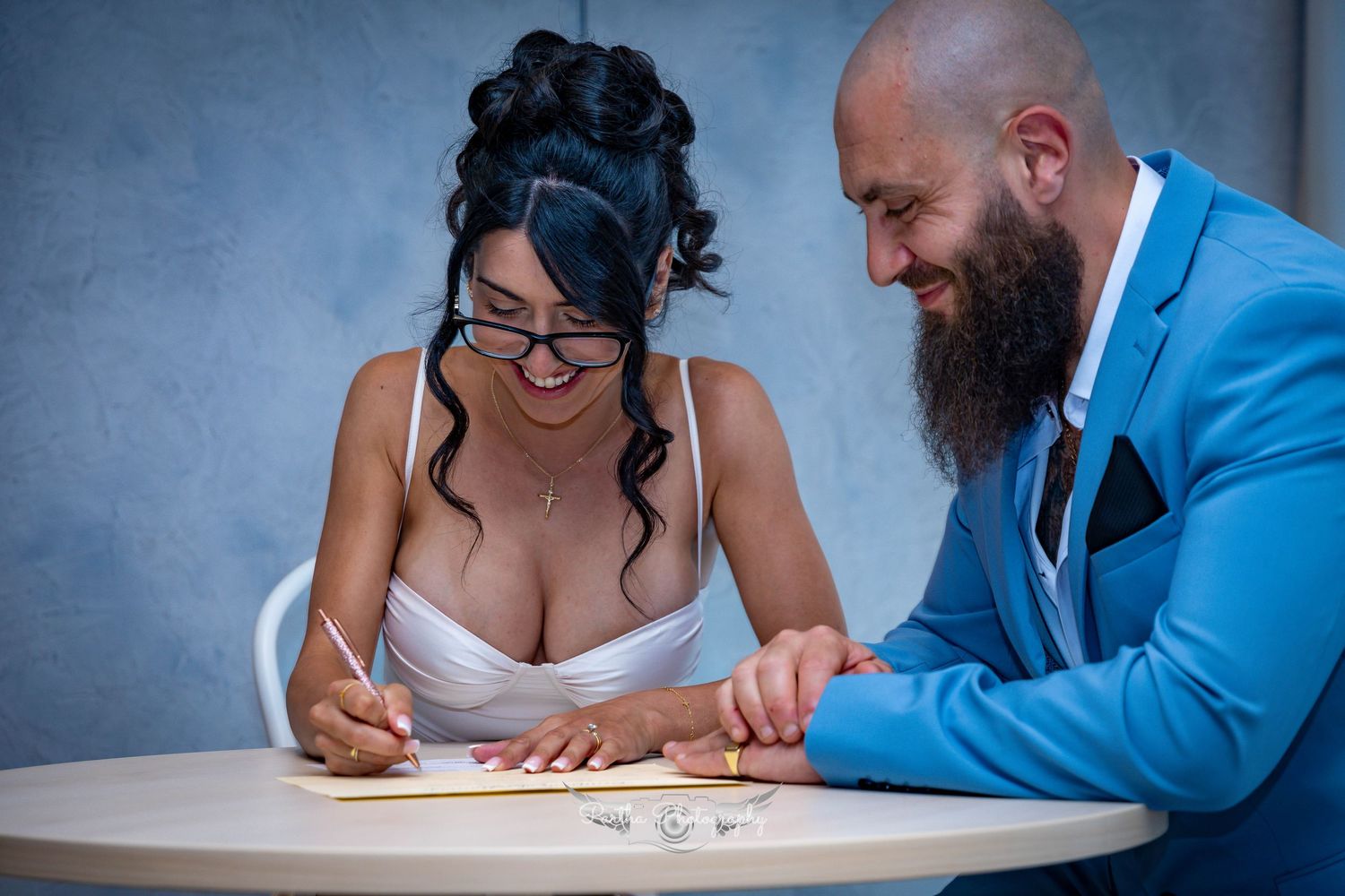 Couple signing marriage documents at a table.