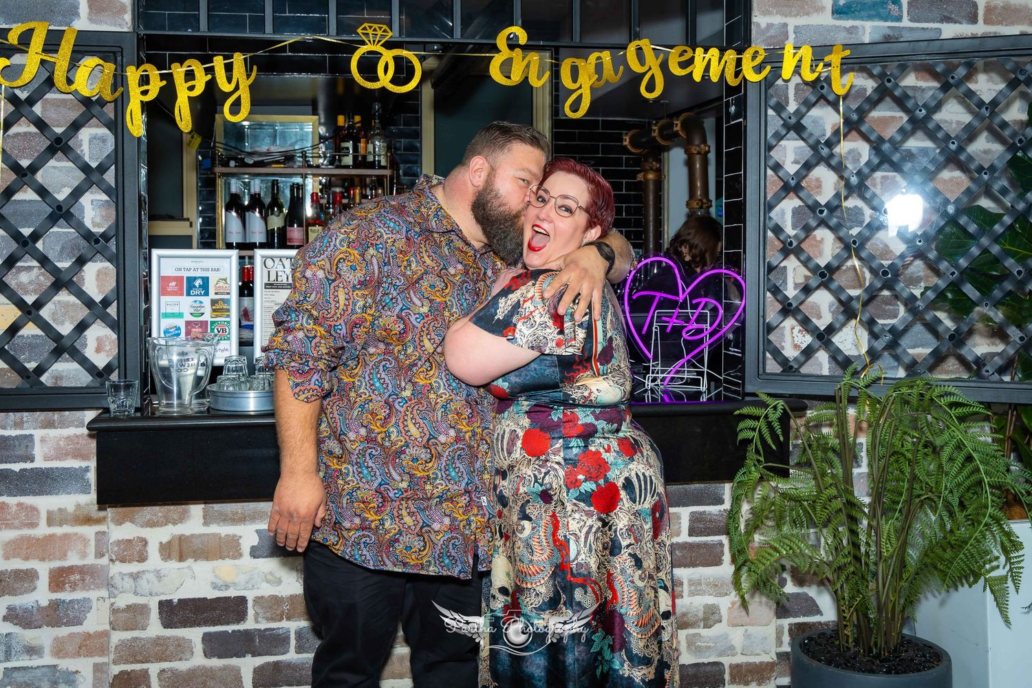 Couple sharing an affectionate moment in front of a storefront with 'Happy' sign.