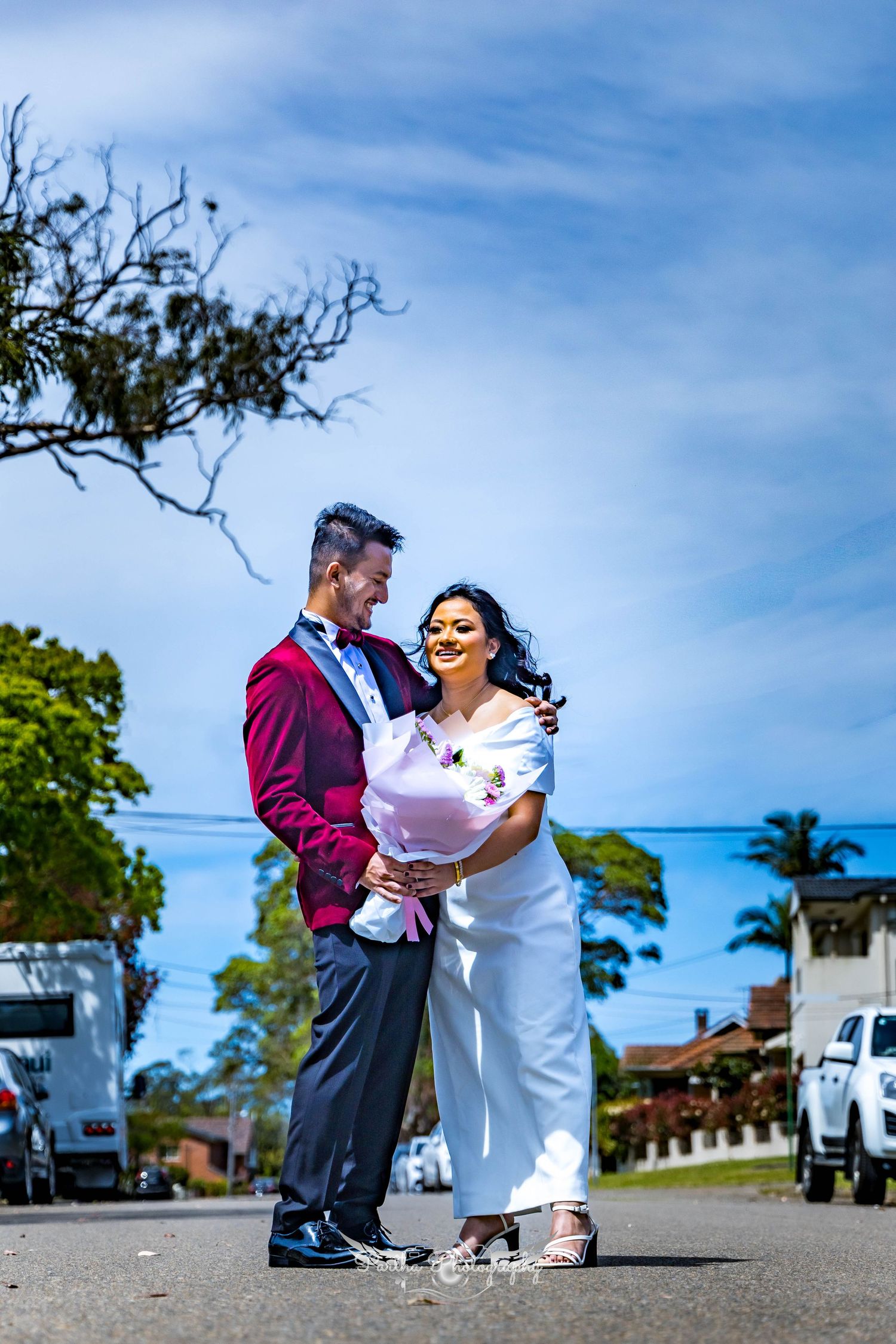 Romantic couple moment captured on a sunny day with blue sky background.