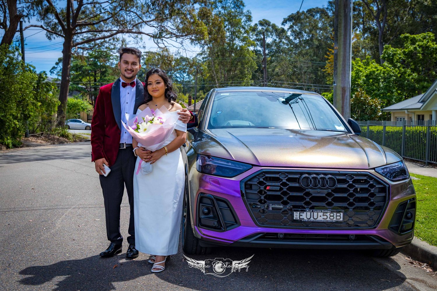 Newlyweds pose beside a purple Audi SUV on their wedding day.