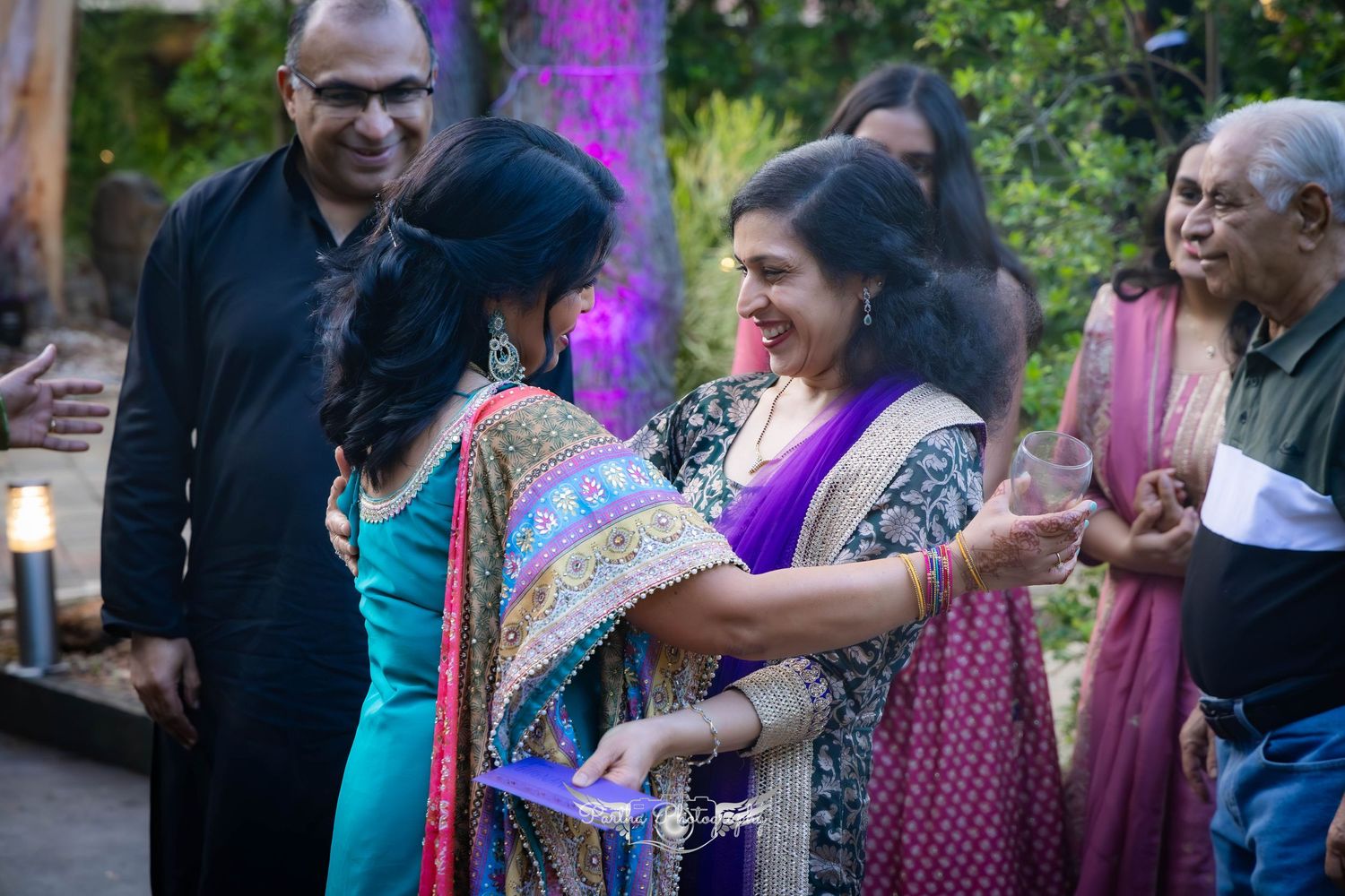 Guests enjoying a festive outdoor celebration with colorful decorations and traditional Indian attire.