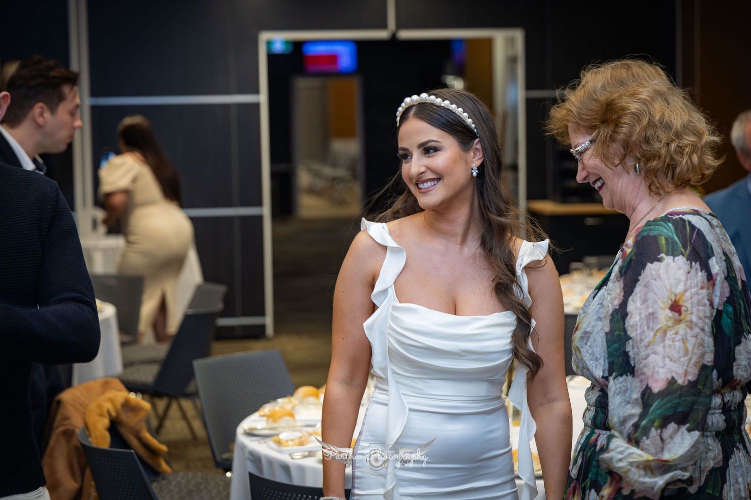 Wedding reception scene with guests mingling near refreshments.
