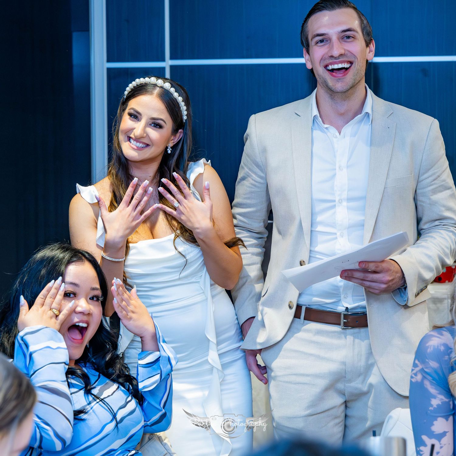 Wedding guests react with joy during a celebration reception with balloon decorations.