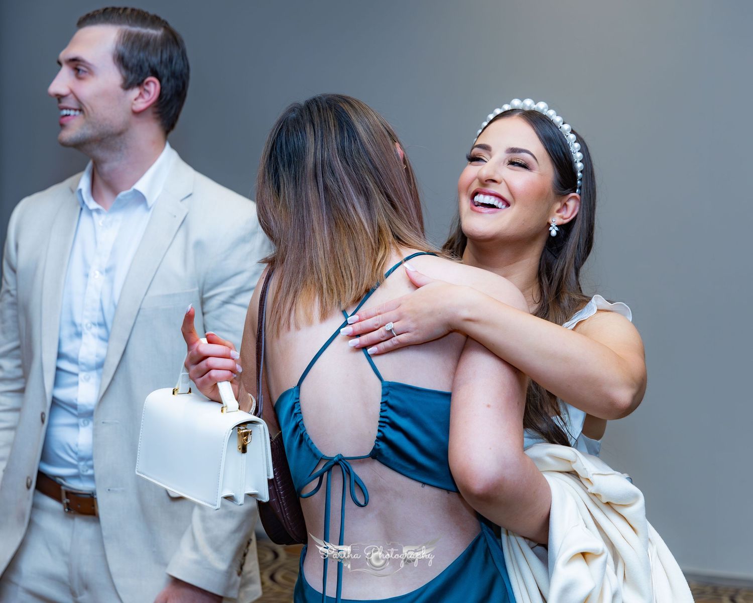 Joyful celebration moment at wedding reception with guests hugging.