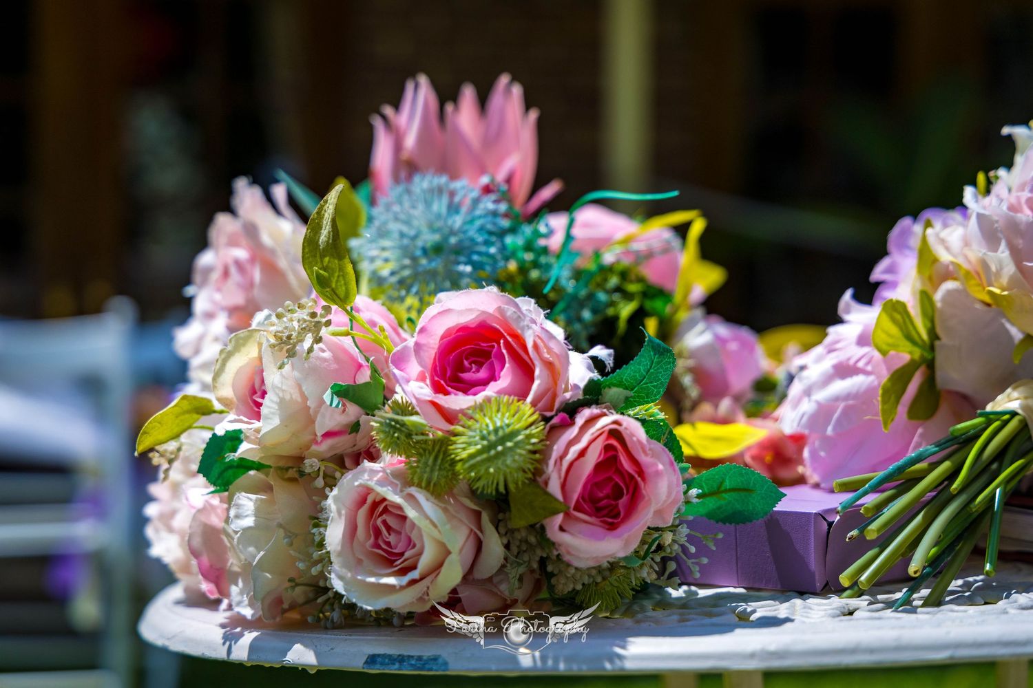 Beautiful floral centerpiece with pink roses and mixed flowers on a table.