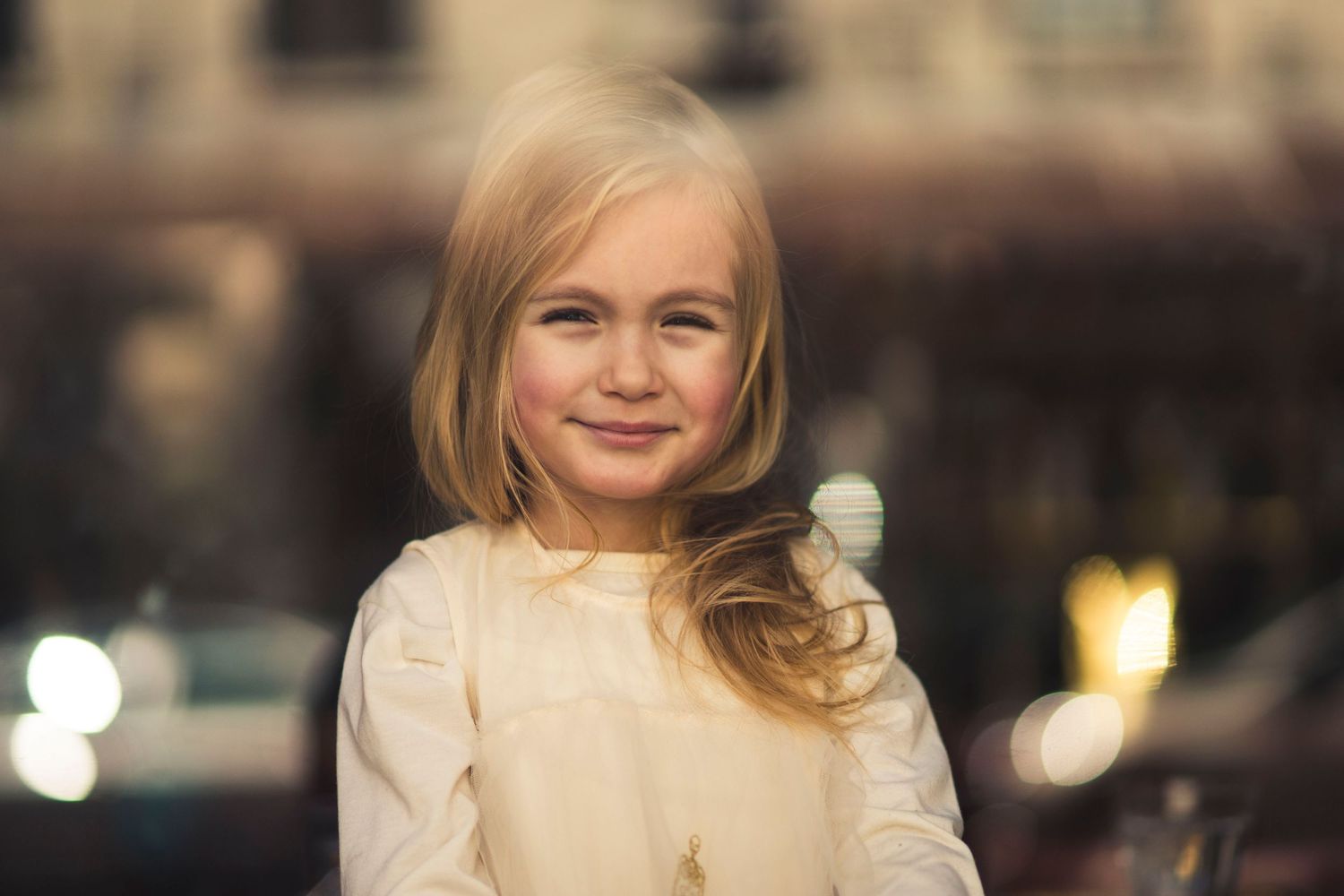 A series of portraits showing someone in a cream colored outfit against a blurred background.