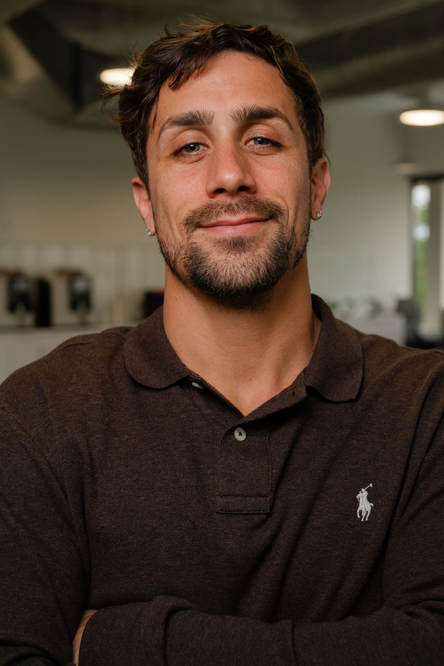 Professional headshot of a person in a brown polo shirt smiling at the camera.