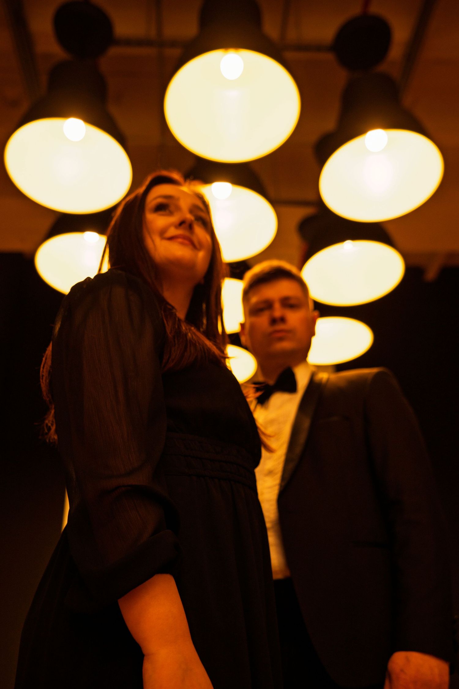 A couple shares romantic moments under warm ceiling lights.