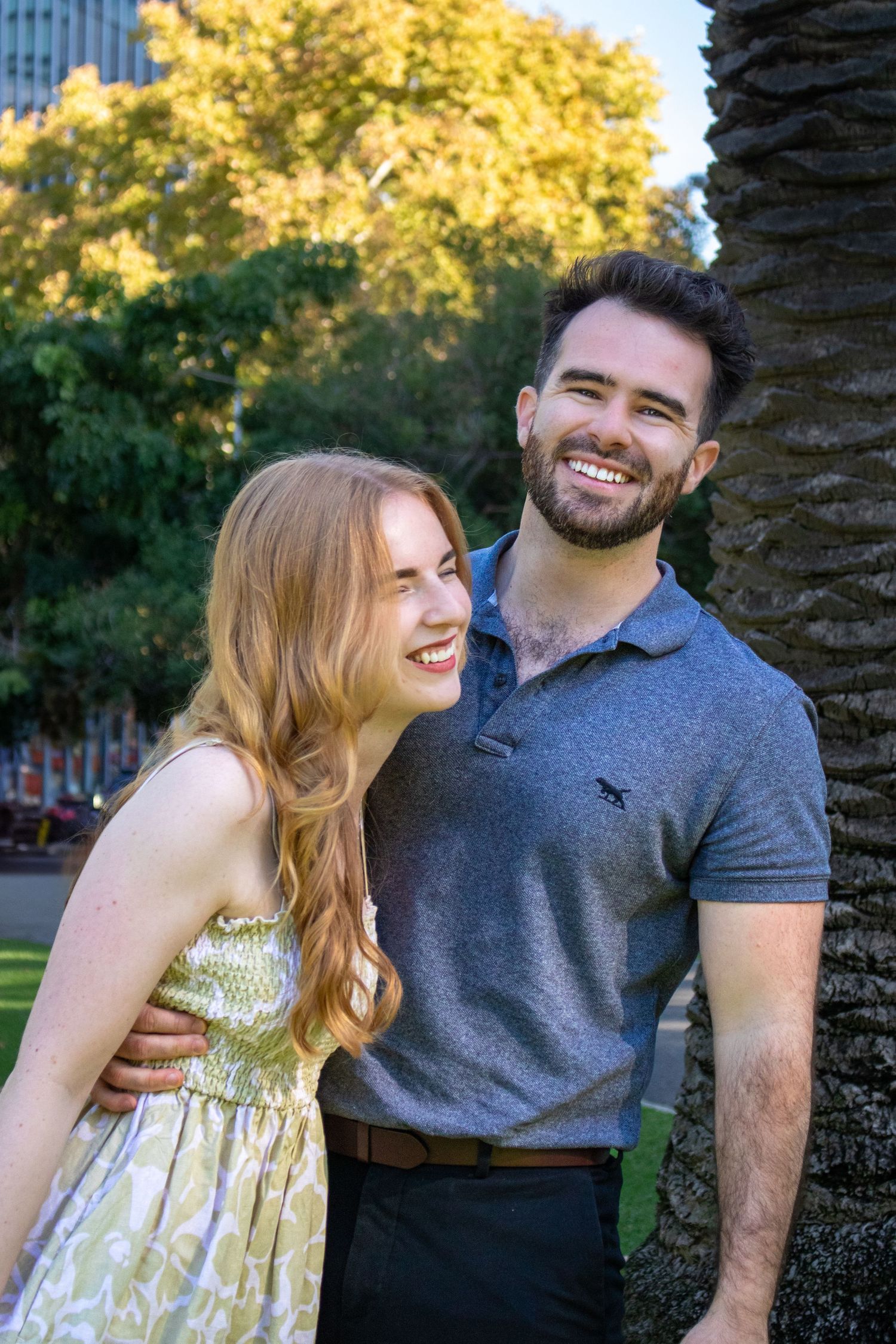 Happy couple sharing a laugh together in an outdoor urban park setting.