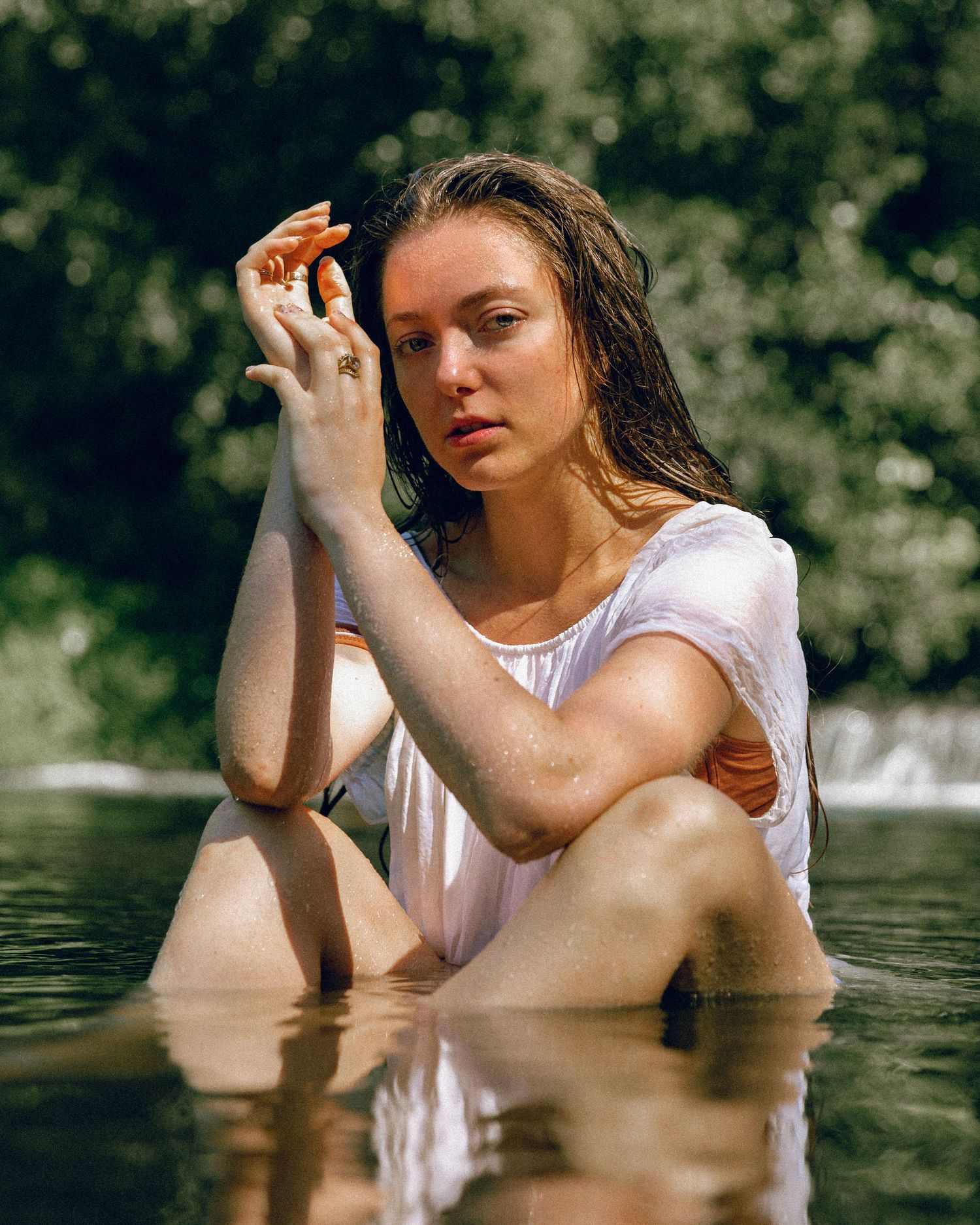 Artistic water portrait in white clothing with wet hair.
