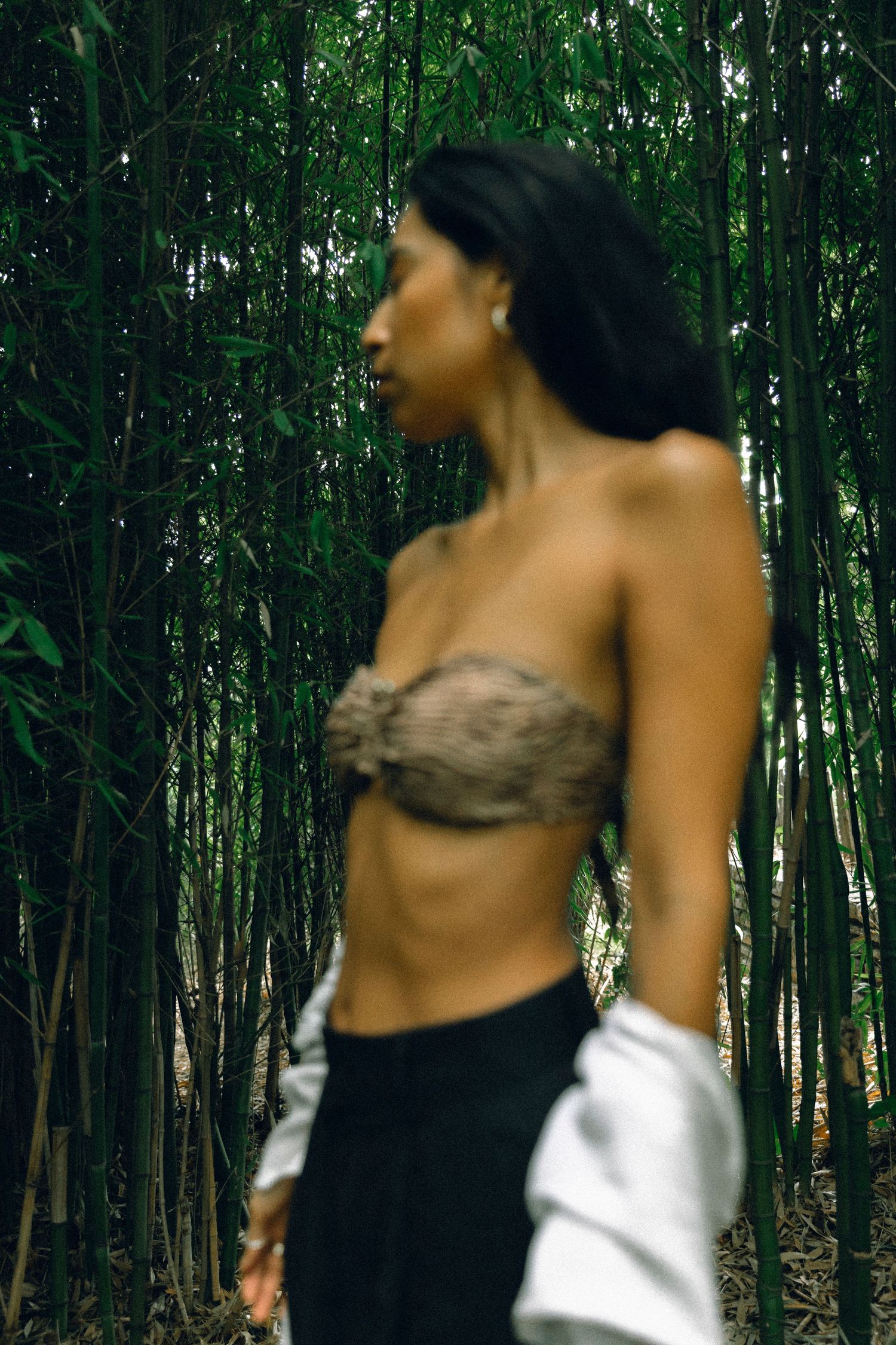 Artistic fashion photograph captured in mystical bamboo forest setting.