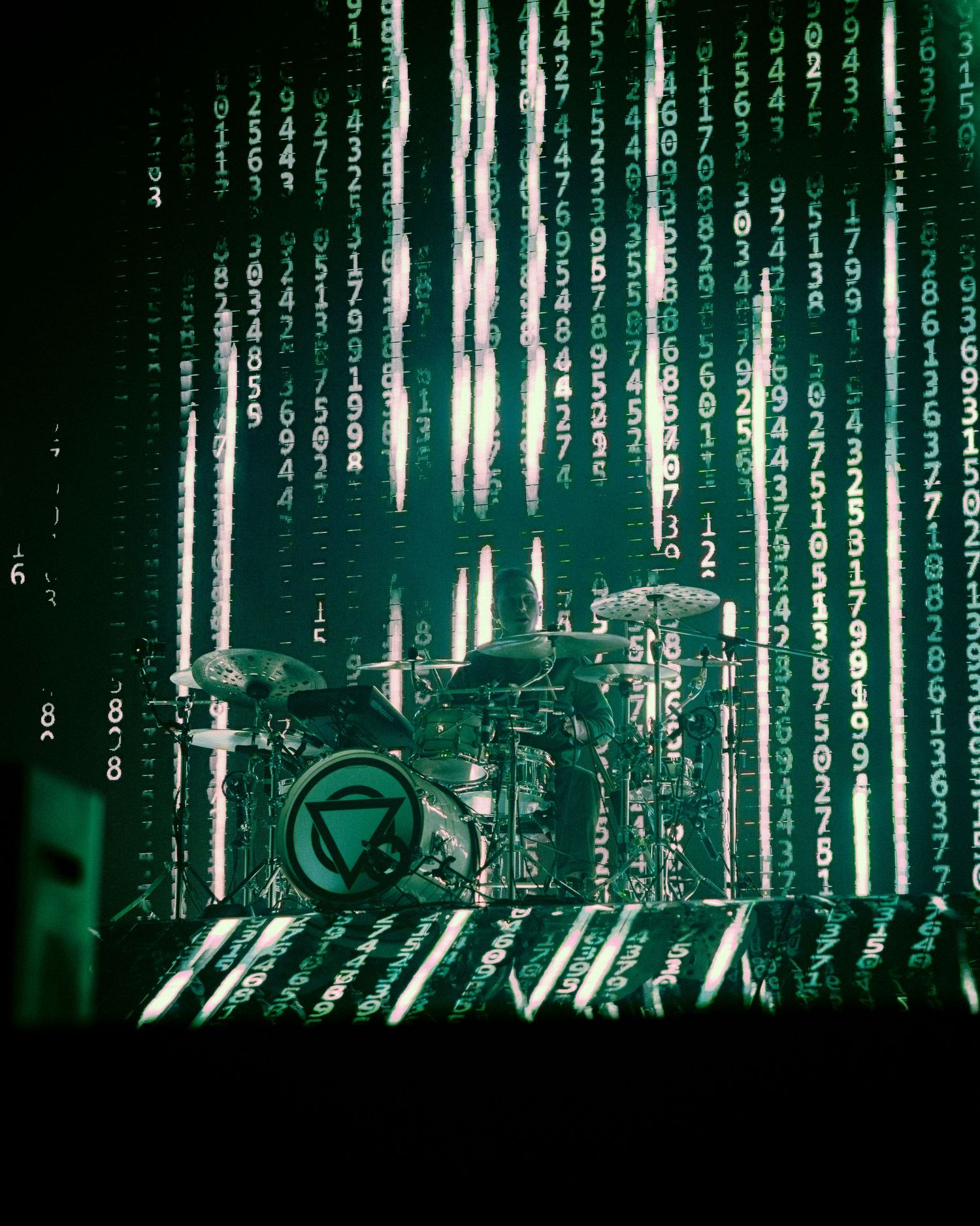 Digital binary matrix code in green on dark background cascading downward in Matrix movie style visual effect.