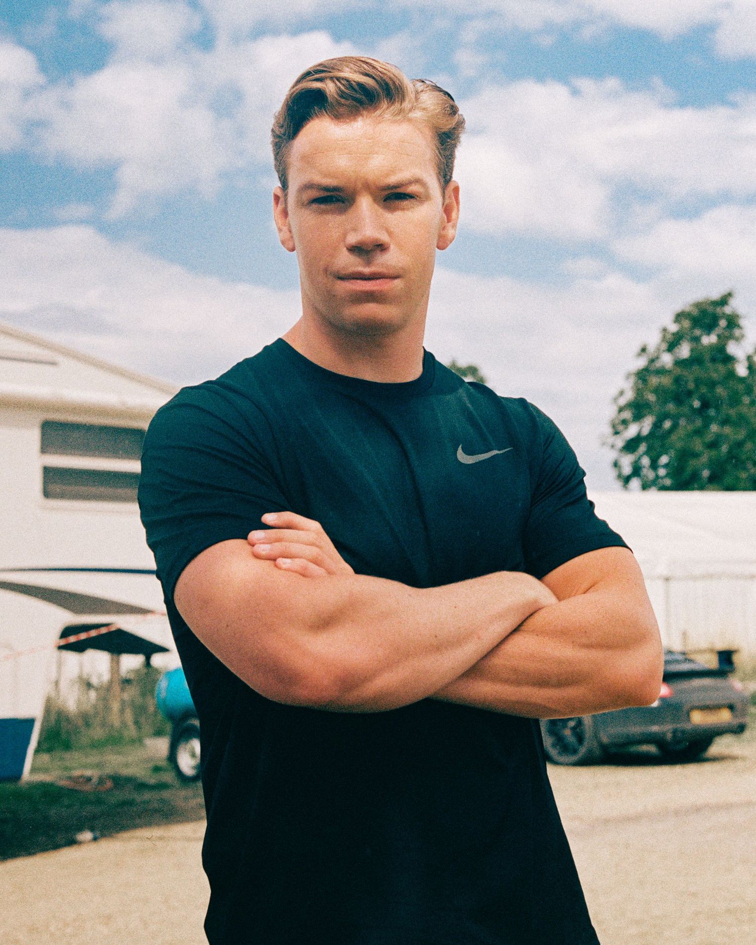 Person in Nike shirt stands with crossed arms in multiple poses outdoors.