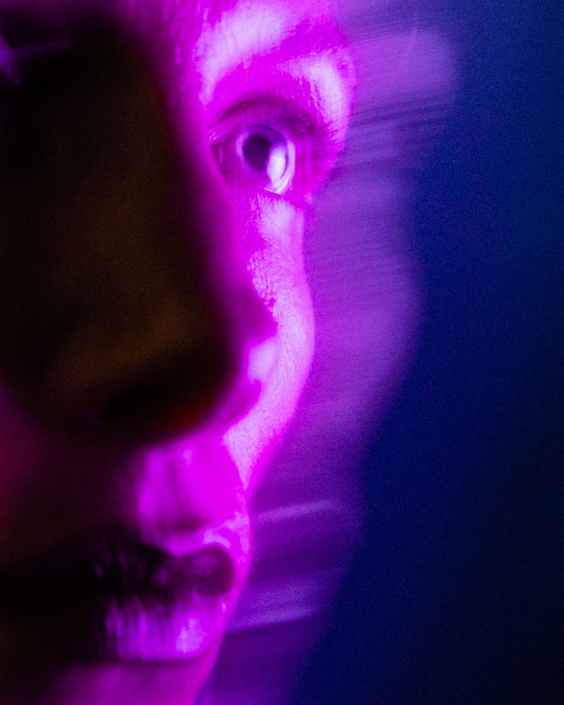Abstract purple and blue light trails creating an ethereal atmospheric effect.