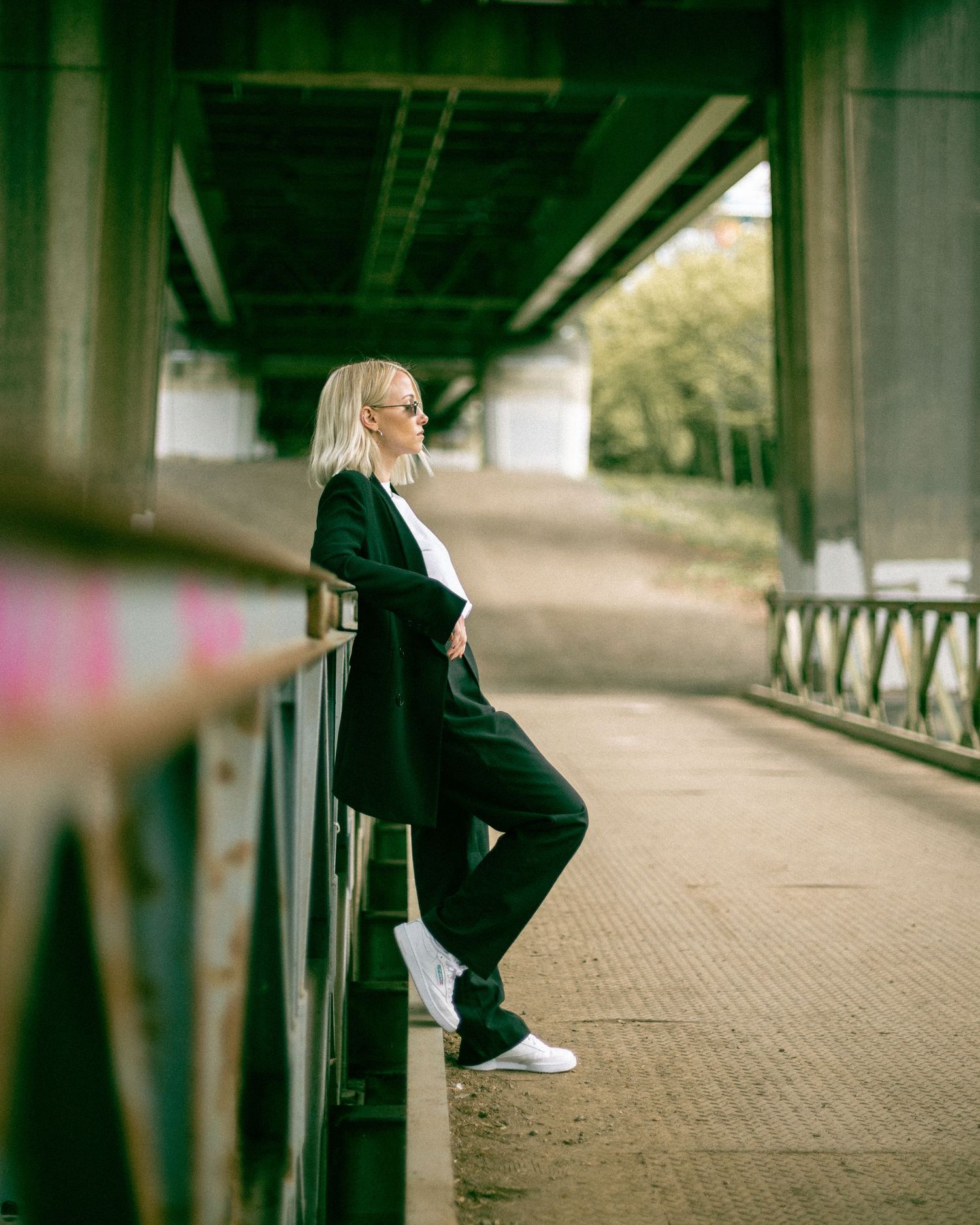 Urban fashion portraits taken under bridge architecture with natural lighting.