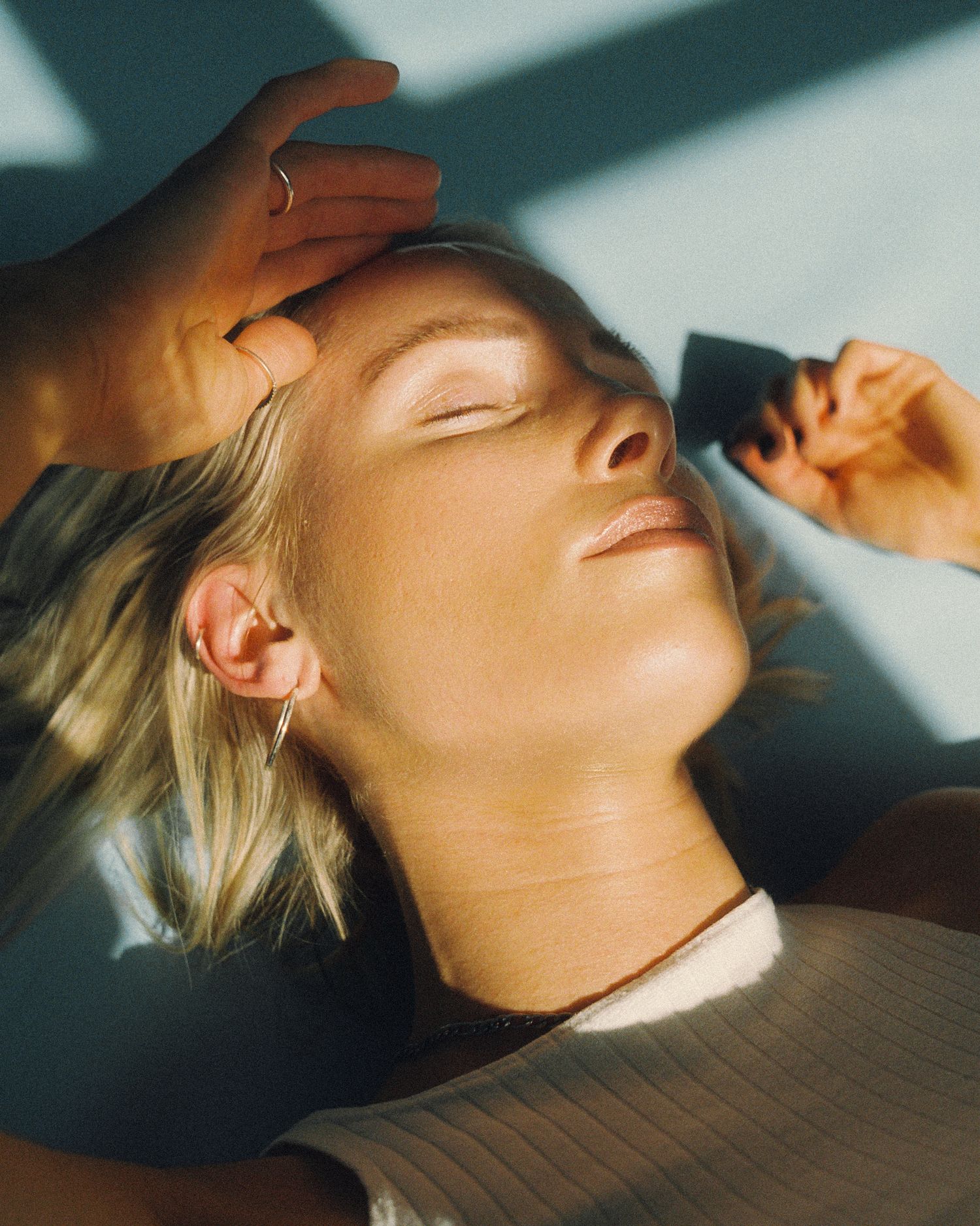 Artistic portrait with dramatic shadows and natural lighting showing relaxed pose.