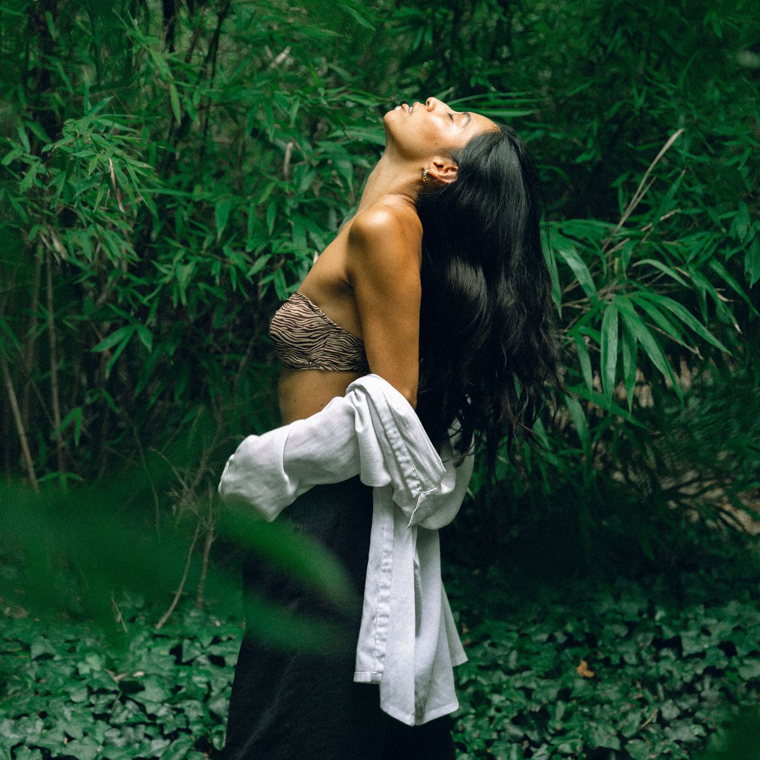 Contemplative dance pose photographed in a serene bamboo garden.