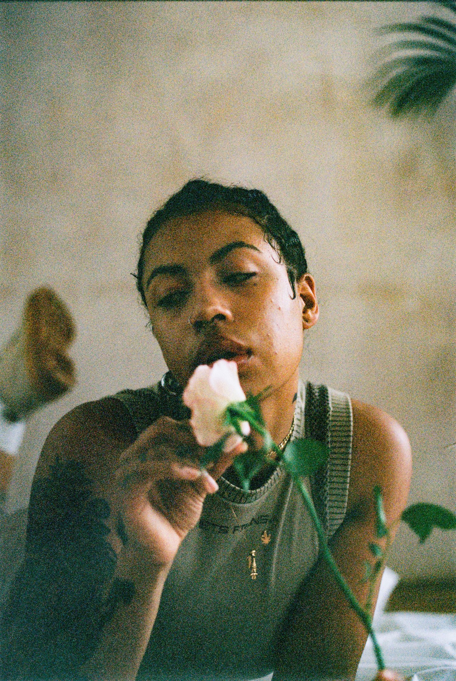 Person enjoying an ice cream cone while wearing a tank top in a dreamy vintage-style photograph.