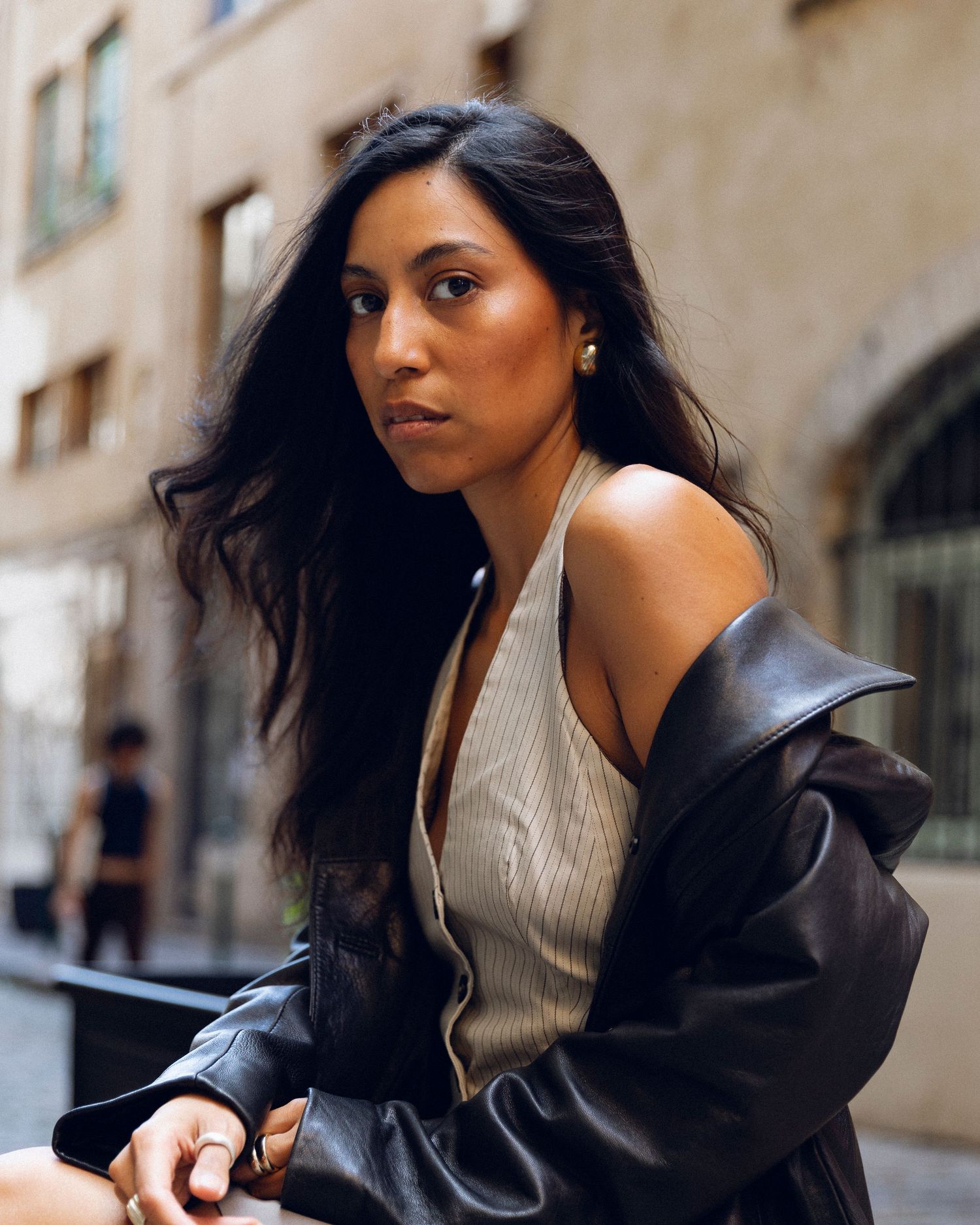 Contemporary fashion photo showing contrast of structured jacket against city backdrop.