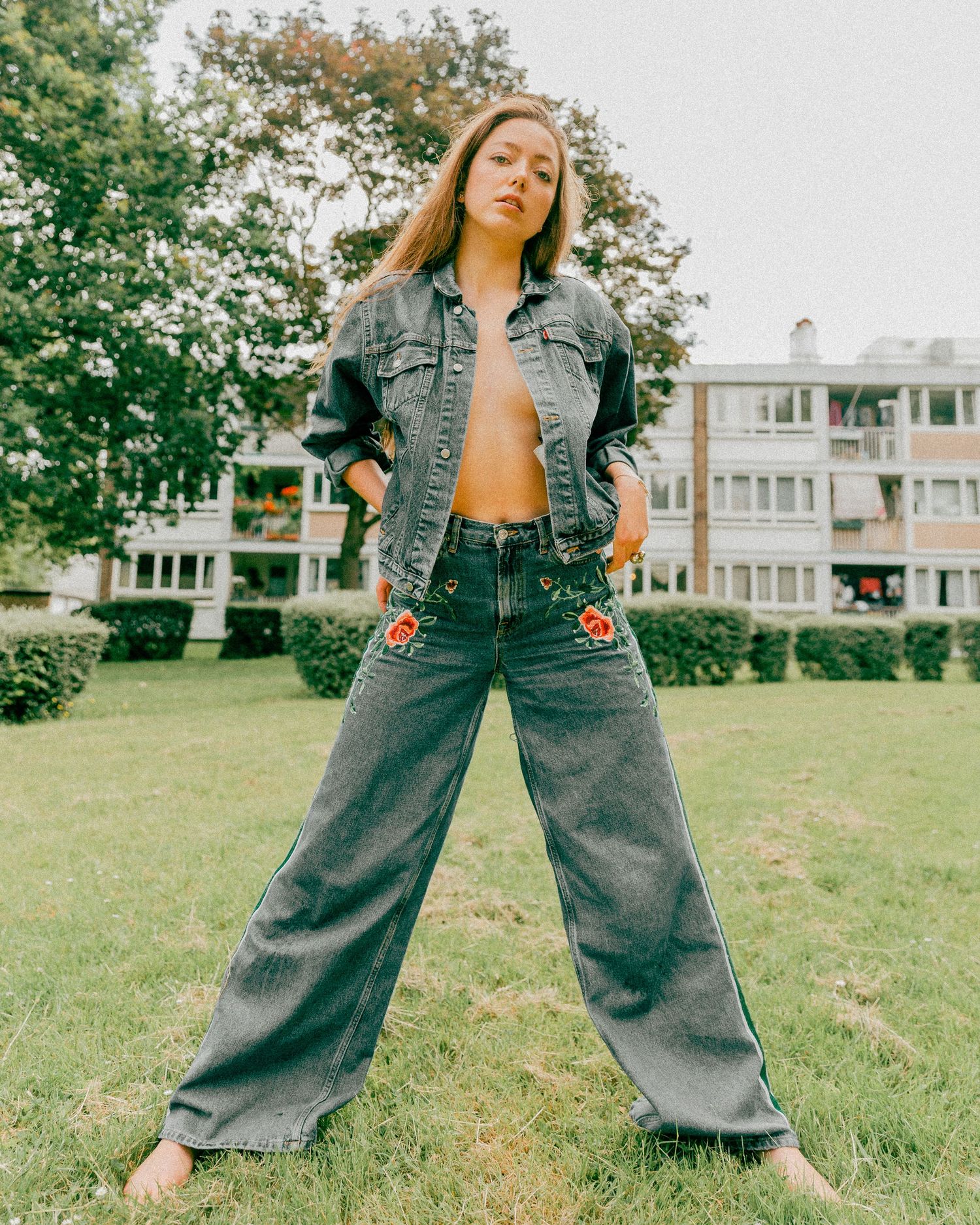 Stylish outdoor photoshoot featuring oversized denim clothing in suburban backyard setting.