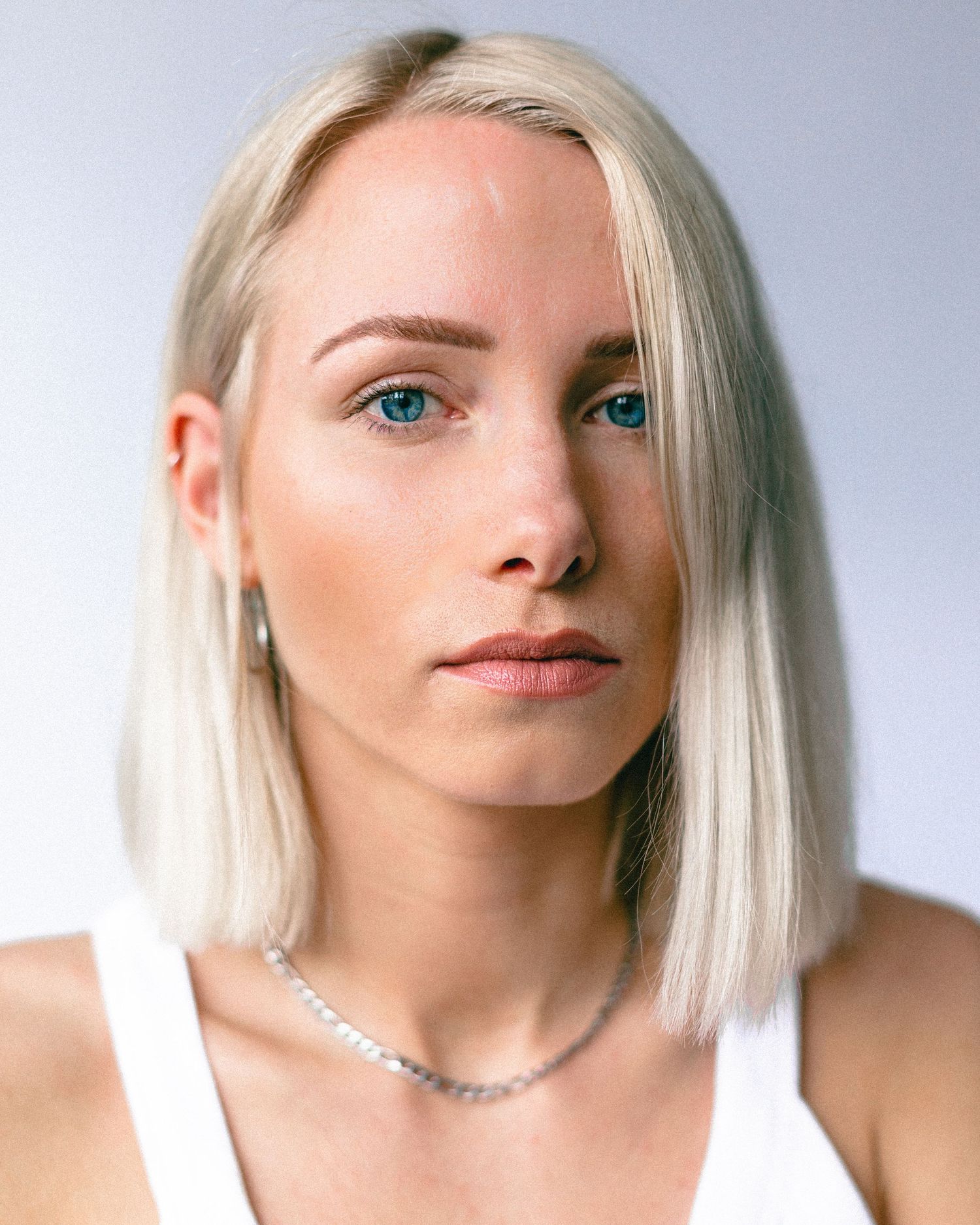 Close-up portrait series showing platinum blonde hair and delicate jewelry against light background.