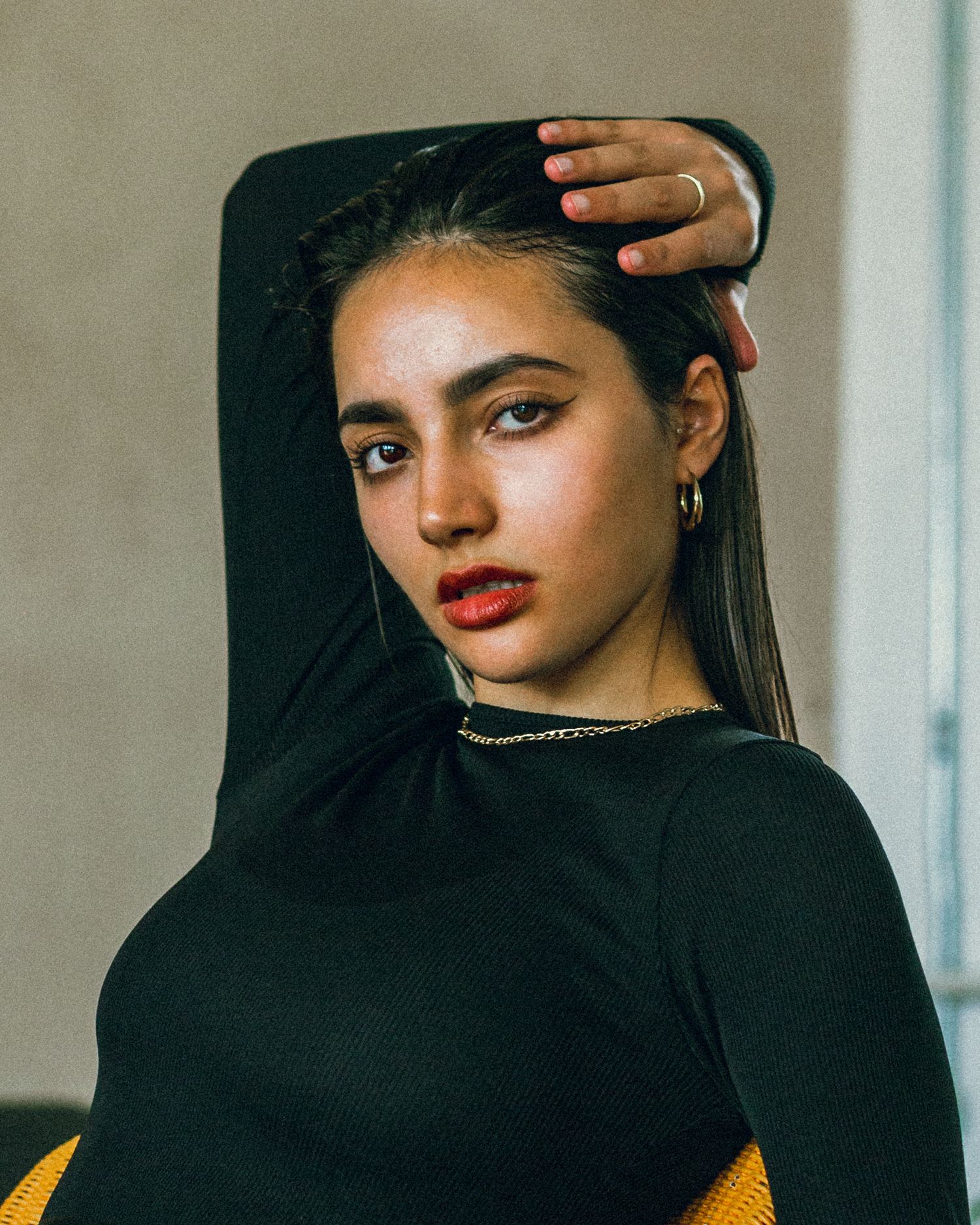 Portrait in black sweater and silver necklace with dramatic makeup.