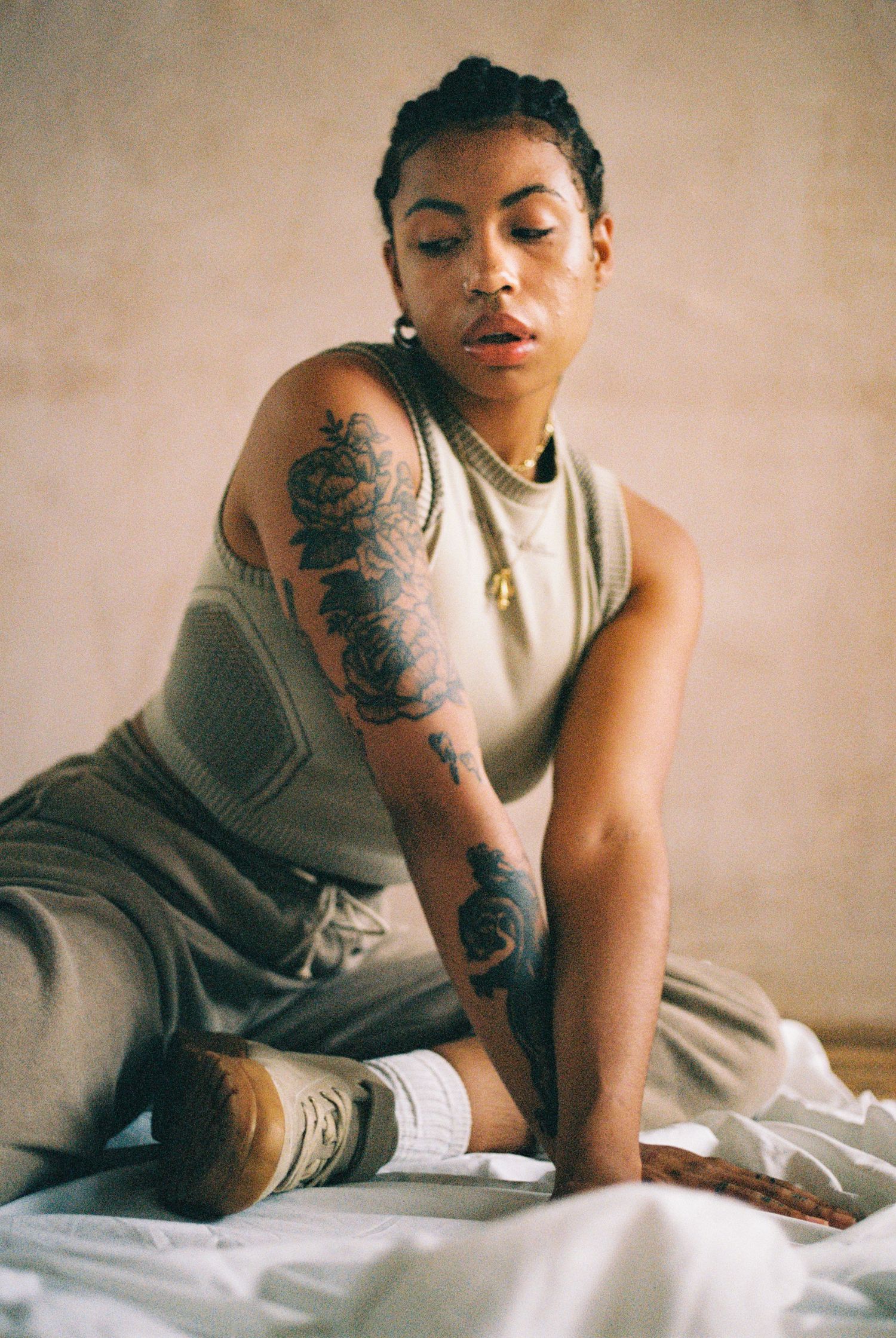 Candid loungewear portrait showing intricate floral arm tattoo design.