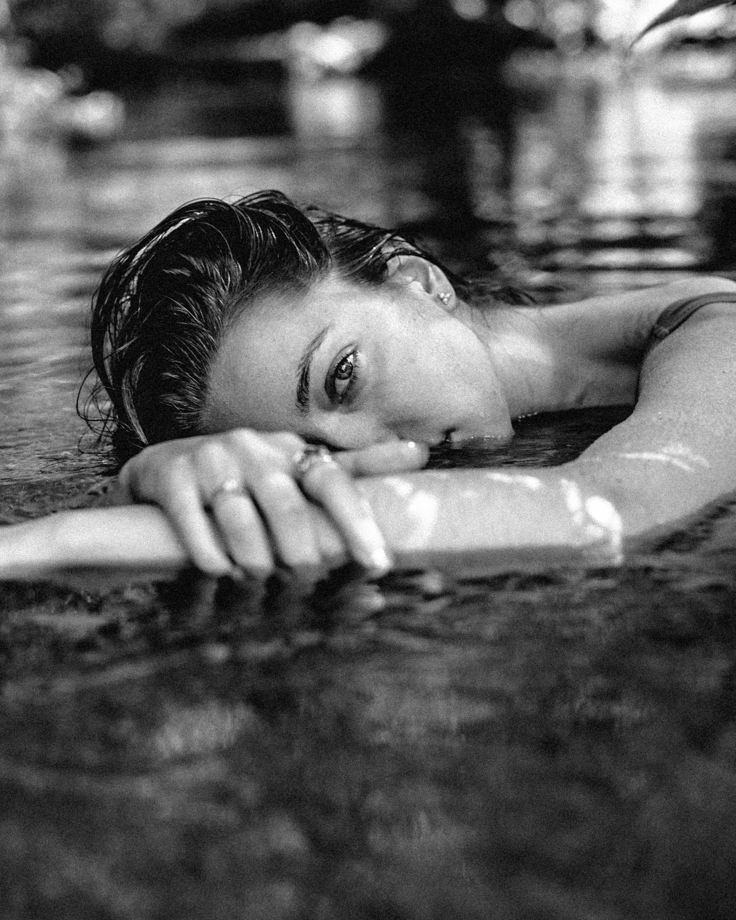 Dramatic black and white water portrait with rippled reflections.