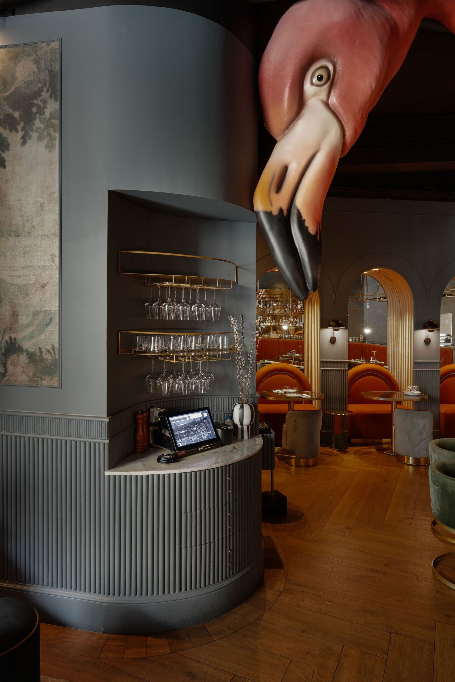 Modern restaurant interior design with curved gray walls, hardwood floors, and sleek minimalist furniture arrangement.