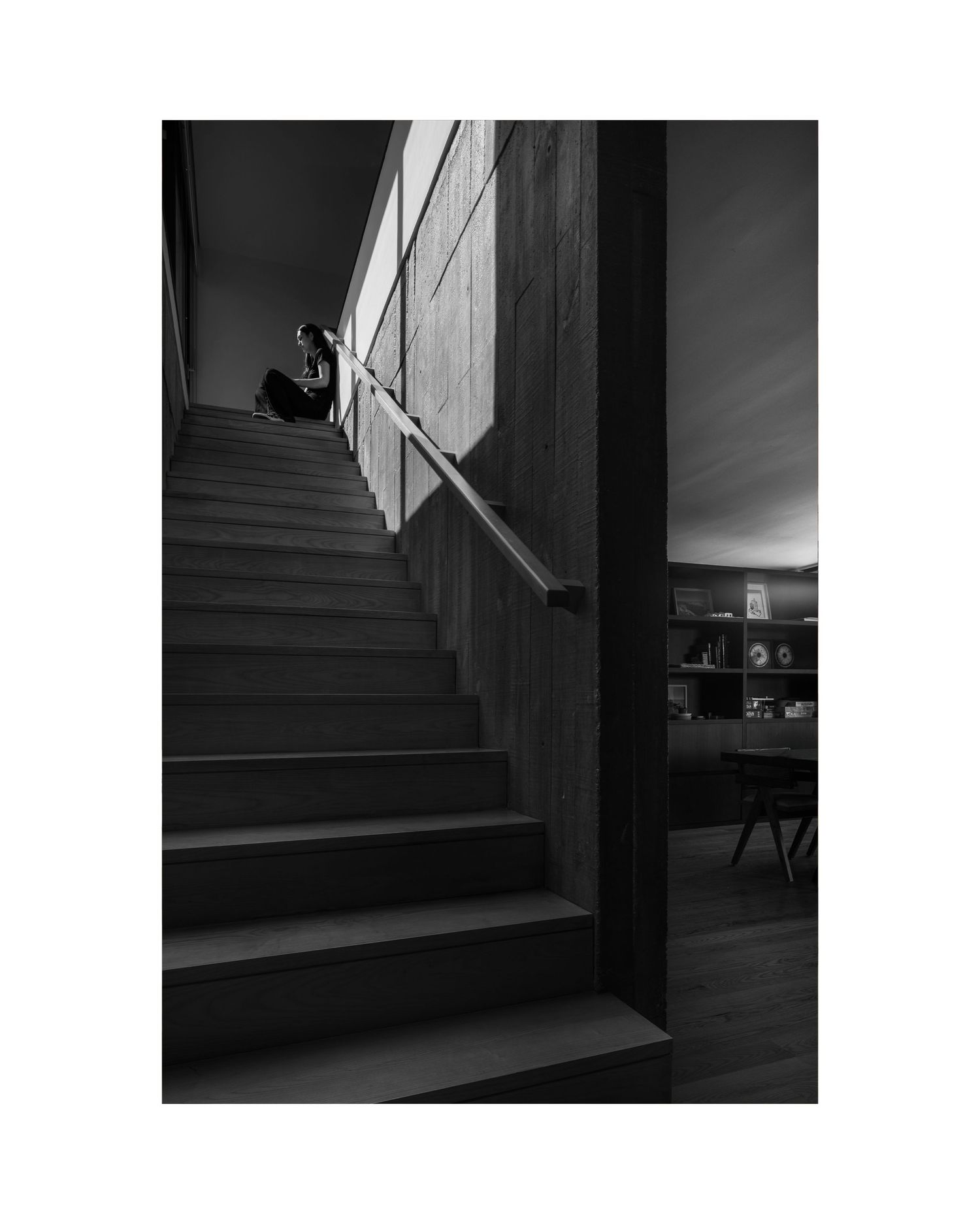 Dramatic black and white photograph of stairs with strong shadows and geometric lines.