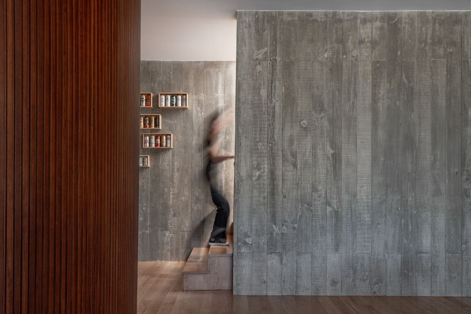 Concrete wall with a series of black and white photographs mounted in a gallery-style installation.