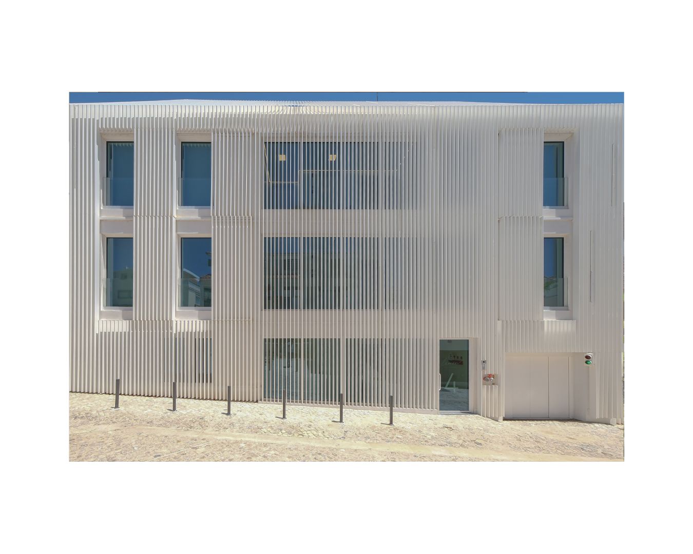 Modern commercial building exterior with corrugated metal siding and blue trim.