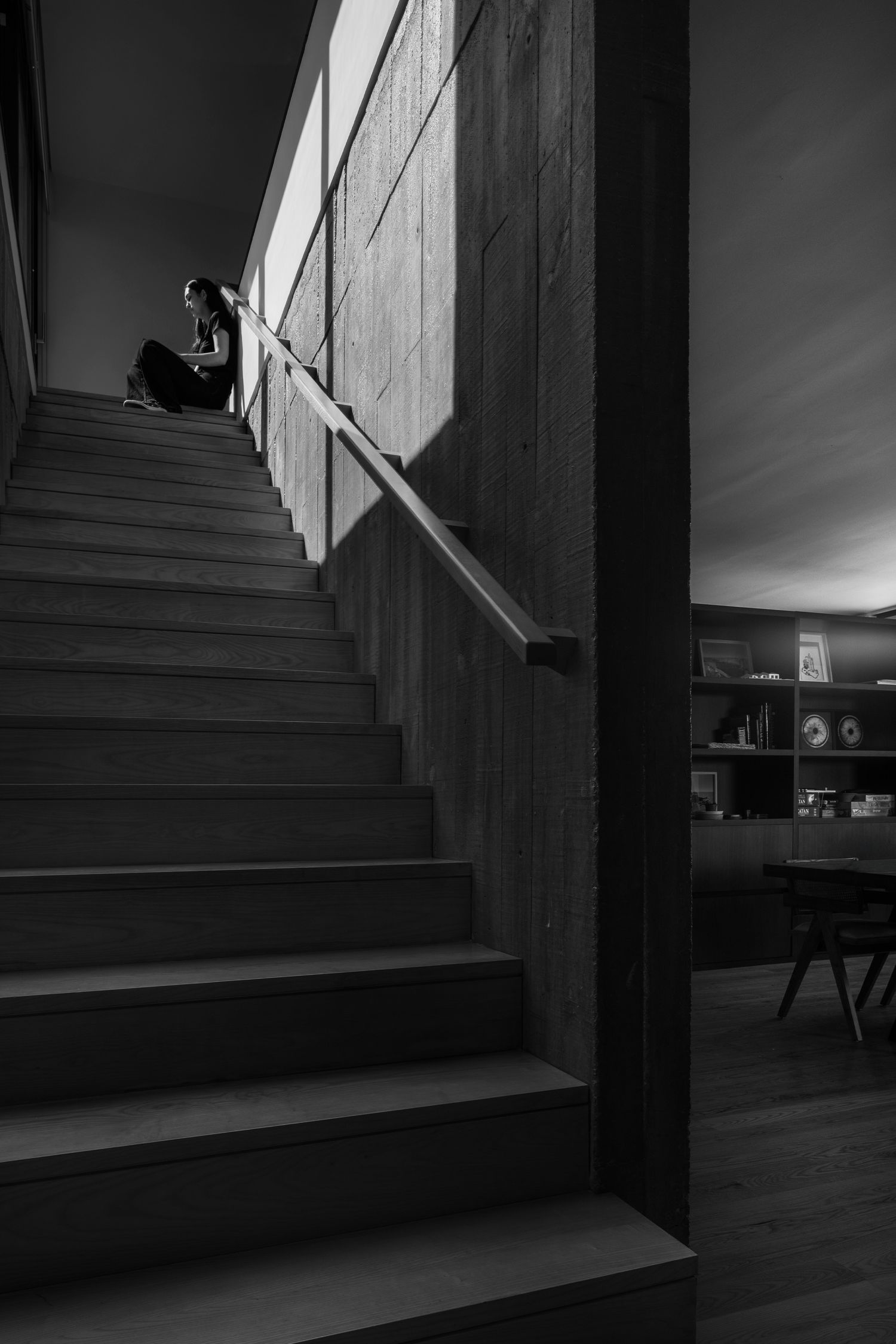 Minimalist staircase with dramatic shadows and clean lines captured in black and white.