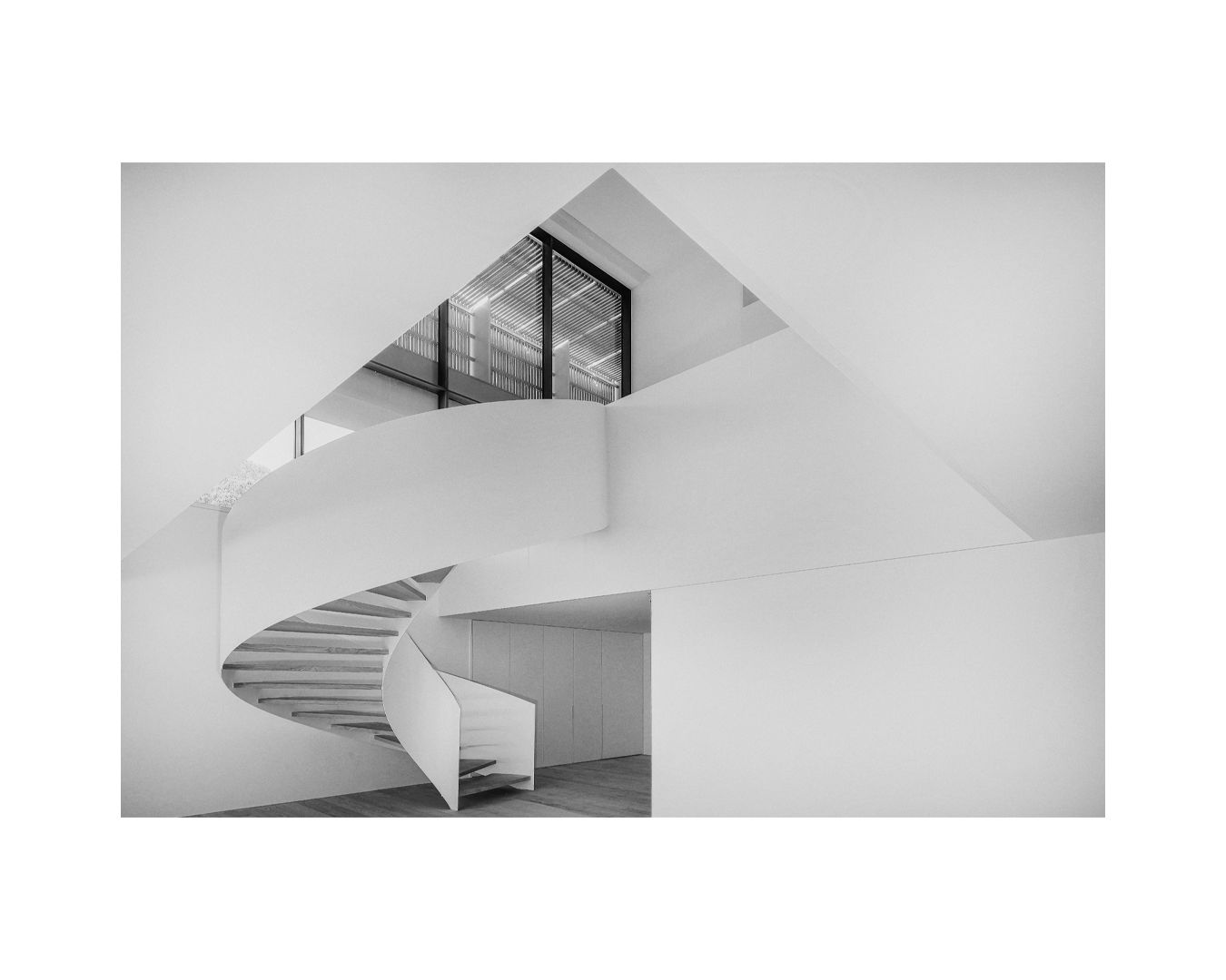 Sculptural white spiral staircase with dramatic curves and architectural details.
