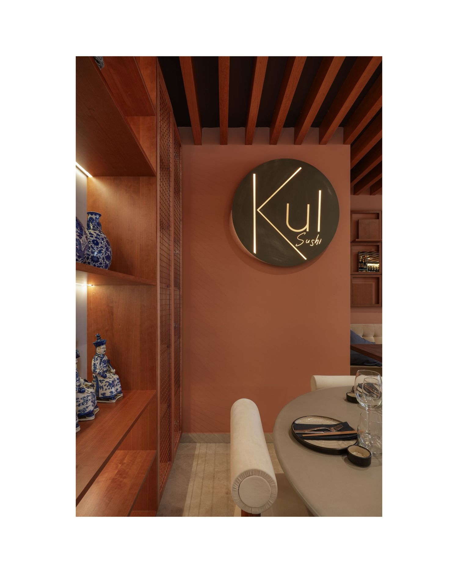 Modern bathroom interior with wooden ceiling beams, brown walls, and contemporary fixtures illuminated by soft lighting.
