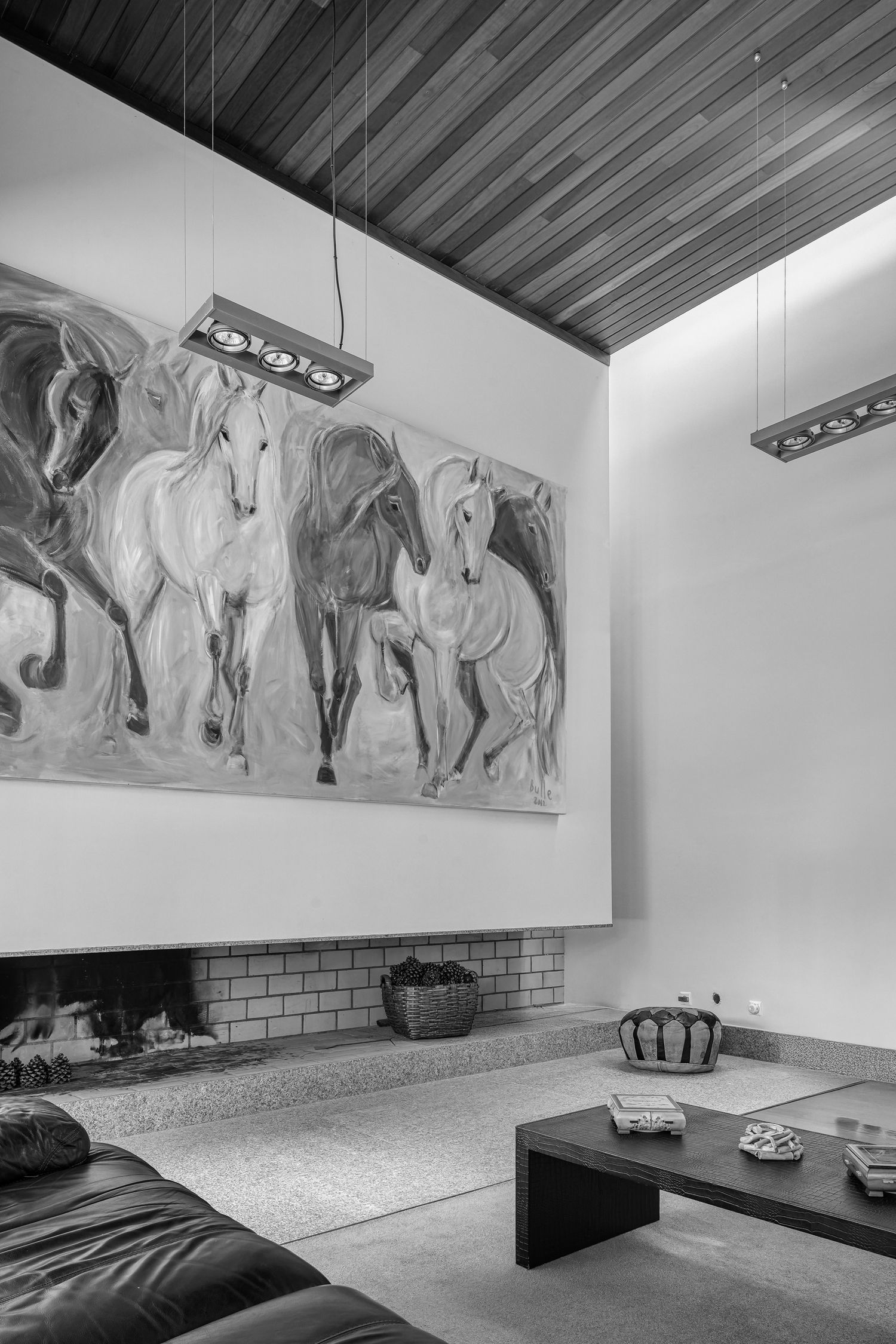Modern living room featuring large horse mural and wooden ceiling in monochrome.