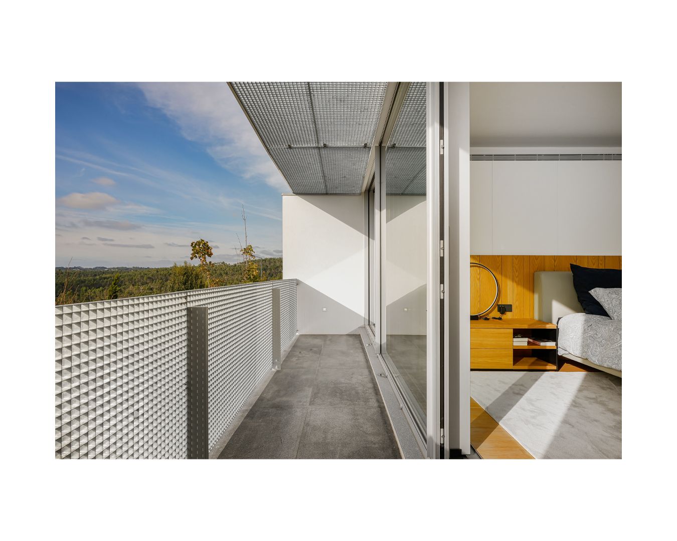 Modern white corridor with perforated walls and geometric architectural details.