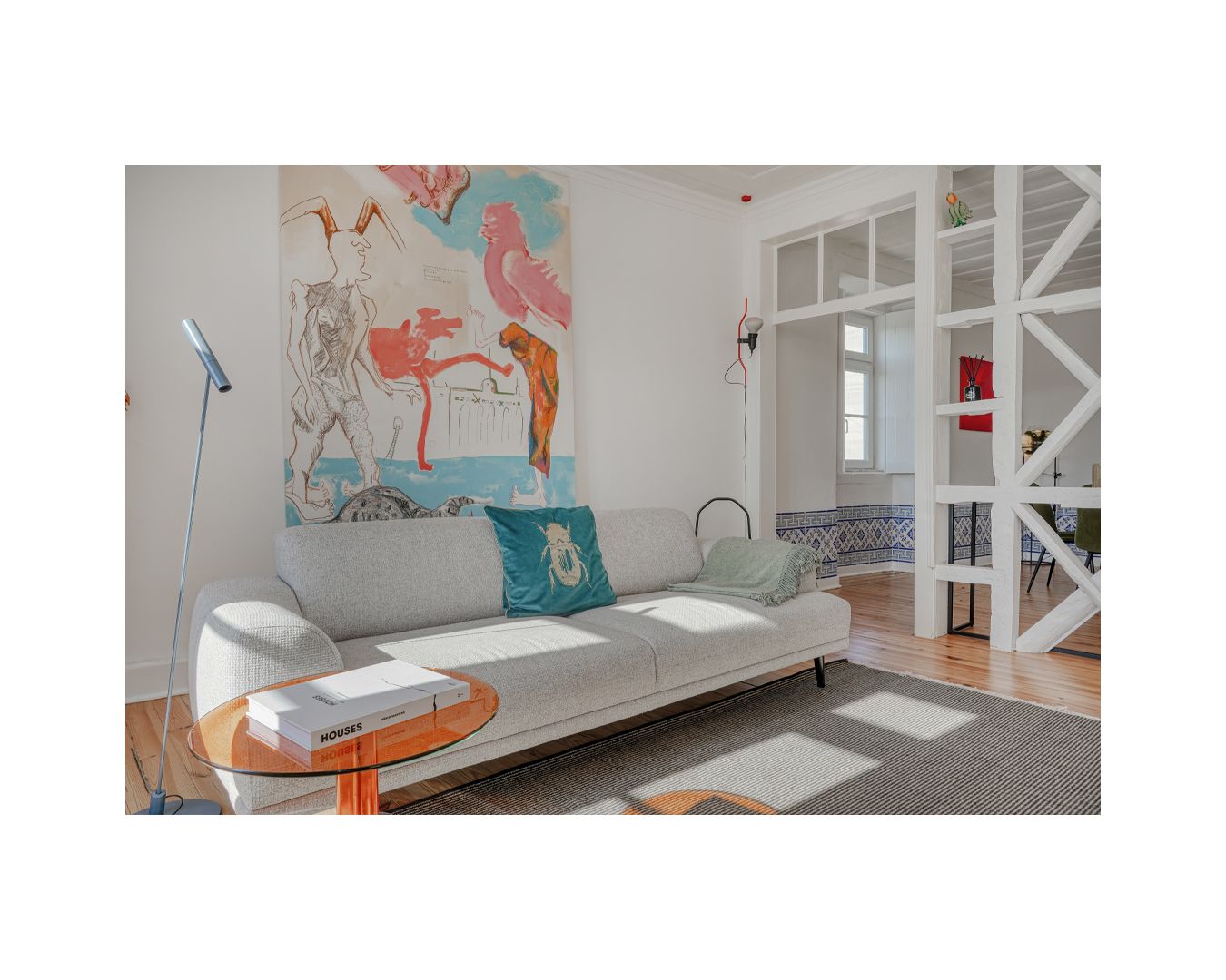 Contemporary white living space with colorful wall art and geometric patterns.