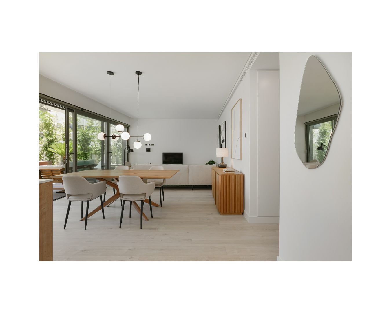 Minimalist open-plan living area with arched details and floor-to-ceiling windows.