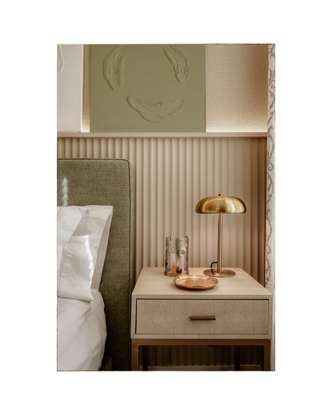 Mid-century modern bedside table with gold dome lamp and decorative wall details.
