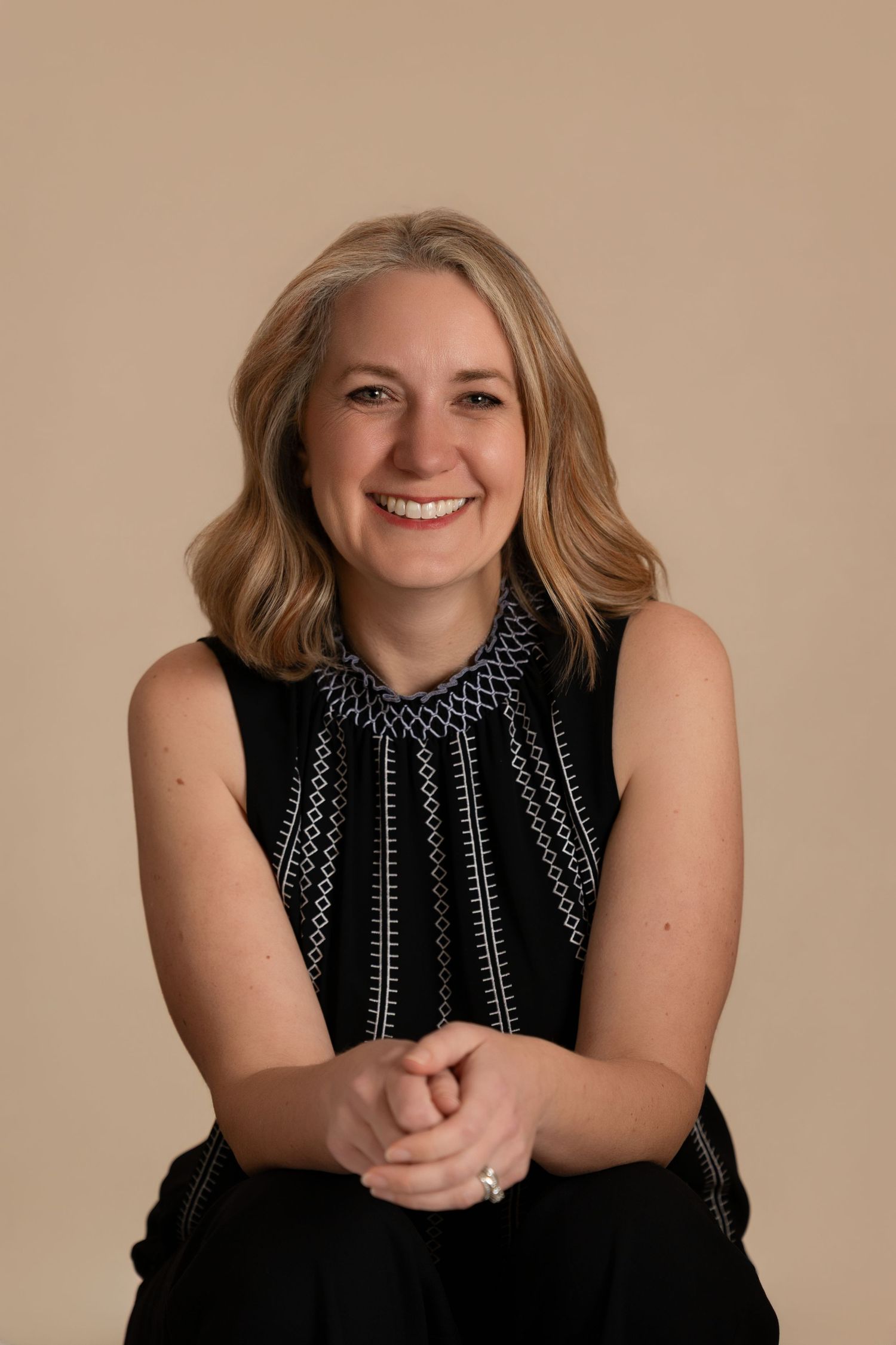 Professional portrait series showing a person in a black sleeveless top against a neutral beige background.