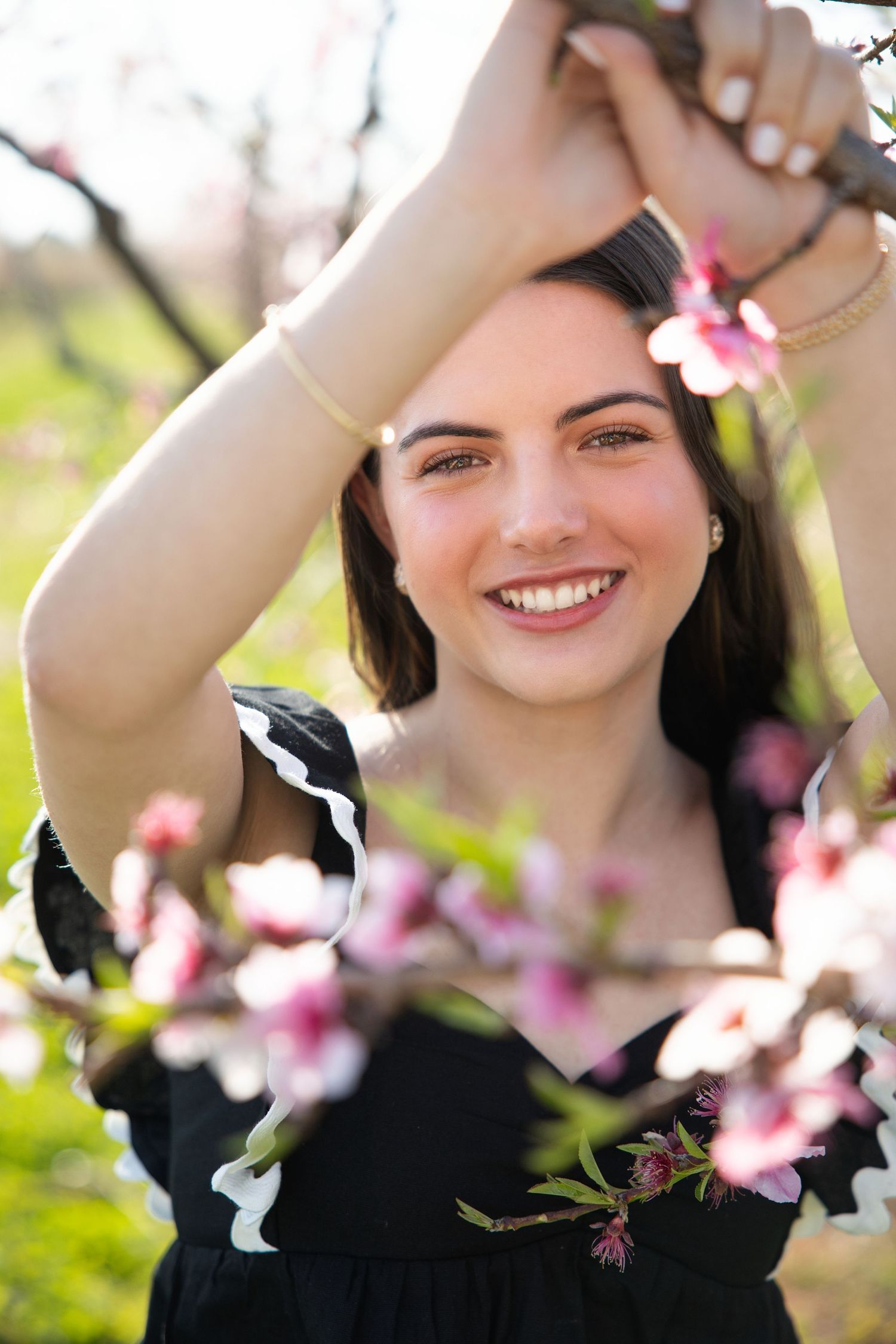 A series of spring portraits with pink cherry blossoms framing the subject against a soft blurred background.