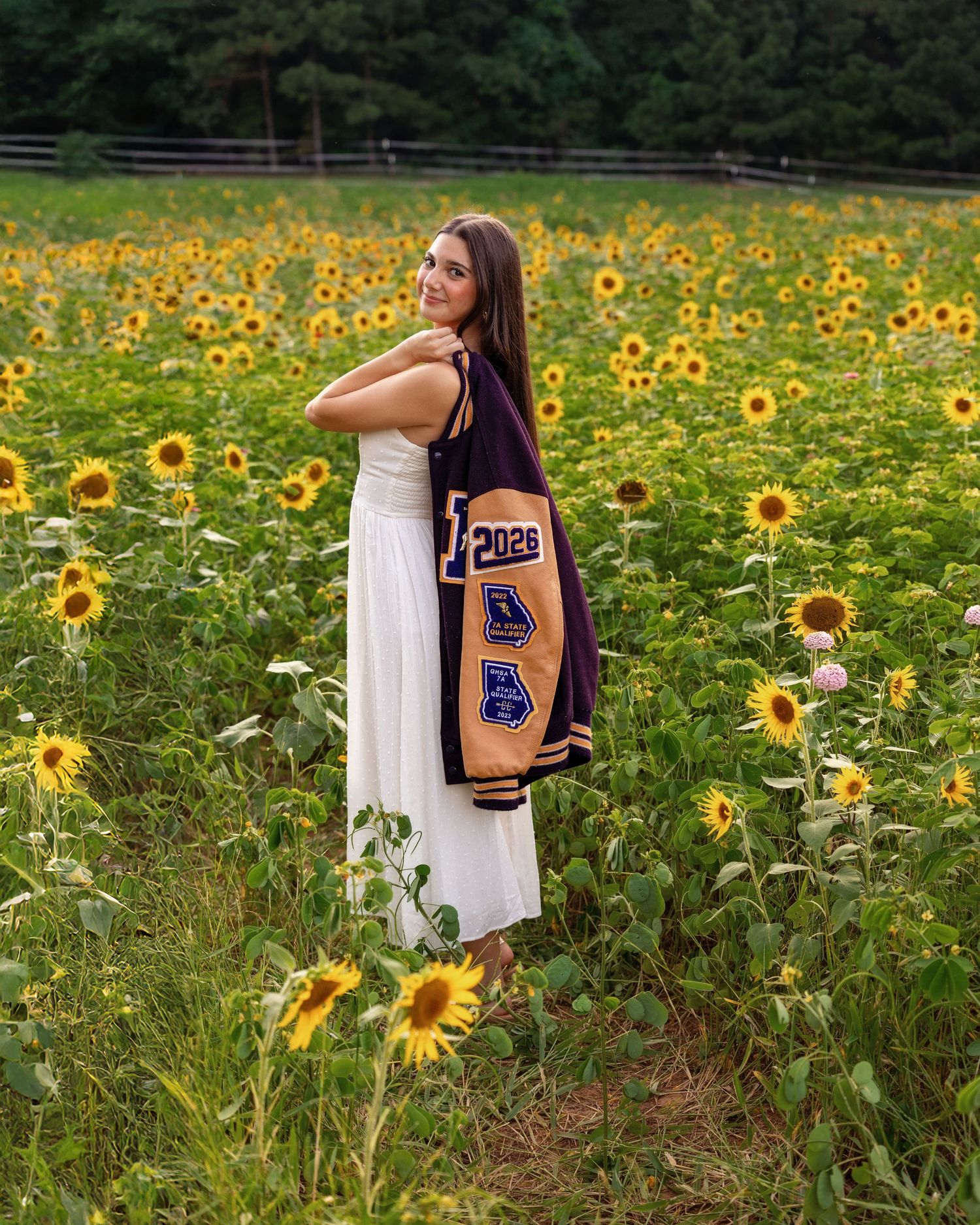 A dreamy summer scene with a flowing white dress among tall sunflowers and rustic wooden fencing.