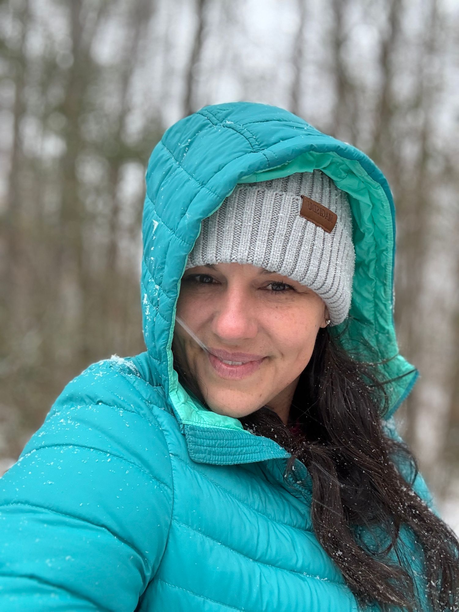 Winter outdoor portrait in teal puffer coat and knit beanie.