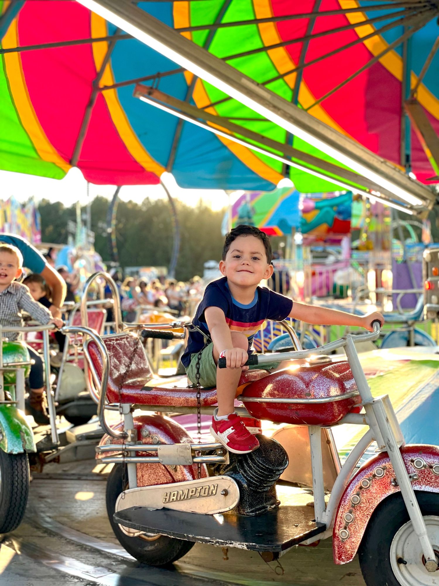 Vintage carnival motorcycle ride with bright multicolored canopy.