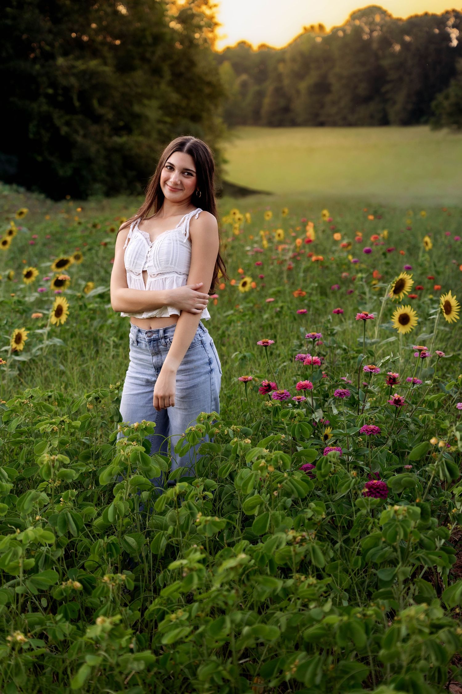 Stunning outdoor portrait among sunflowers and wildflowers at sunset.