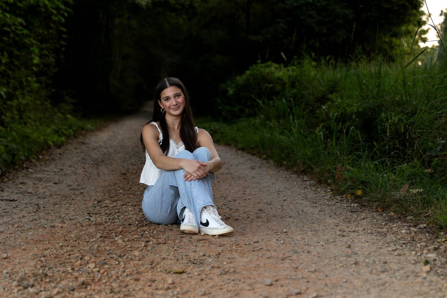 Natural outdoor photography session on a winding dirt path through woods.