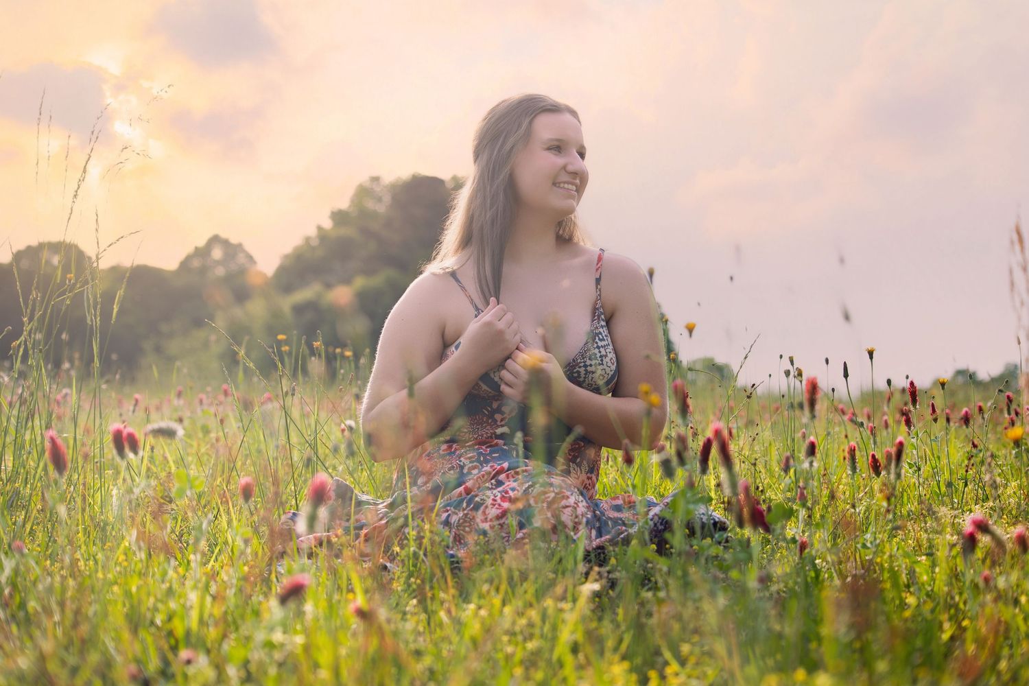 Dreamy sunset portrait session in wildflower field with warm golden light.